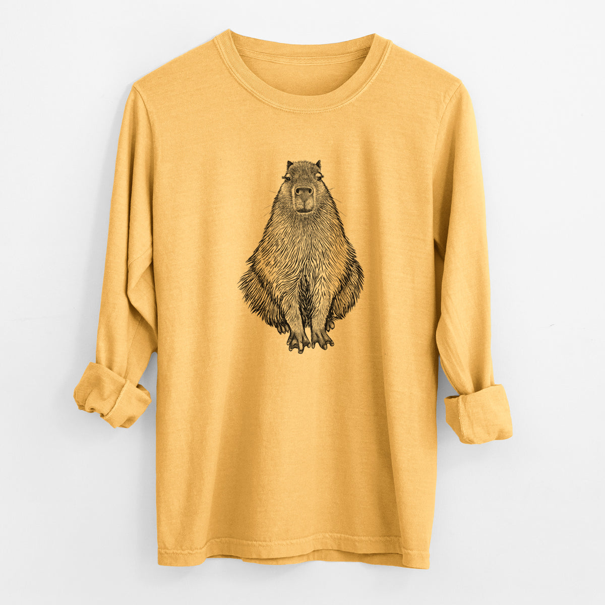 Golden wheat yellow Comfort Colors long sleeve shirt laid flat with the cuffs rolled, printed with a detailed black ink illustration of a capybara sitting and facing forward.