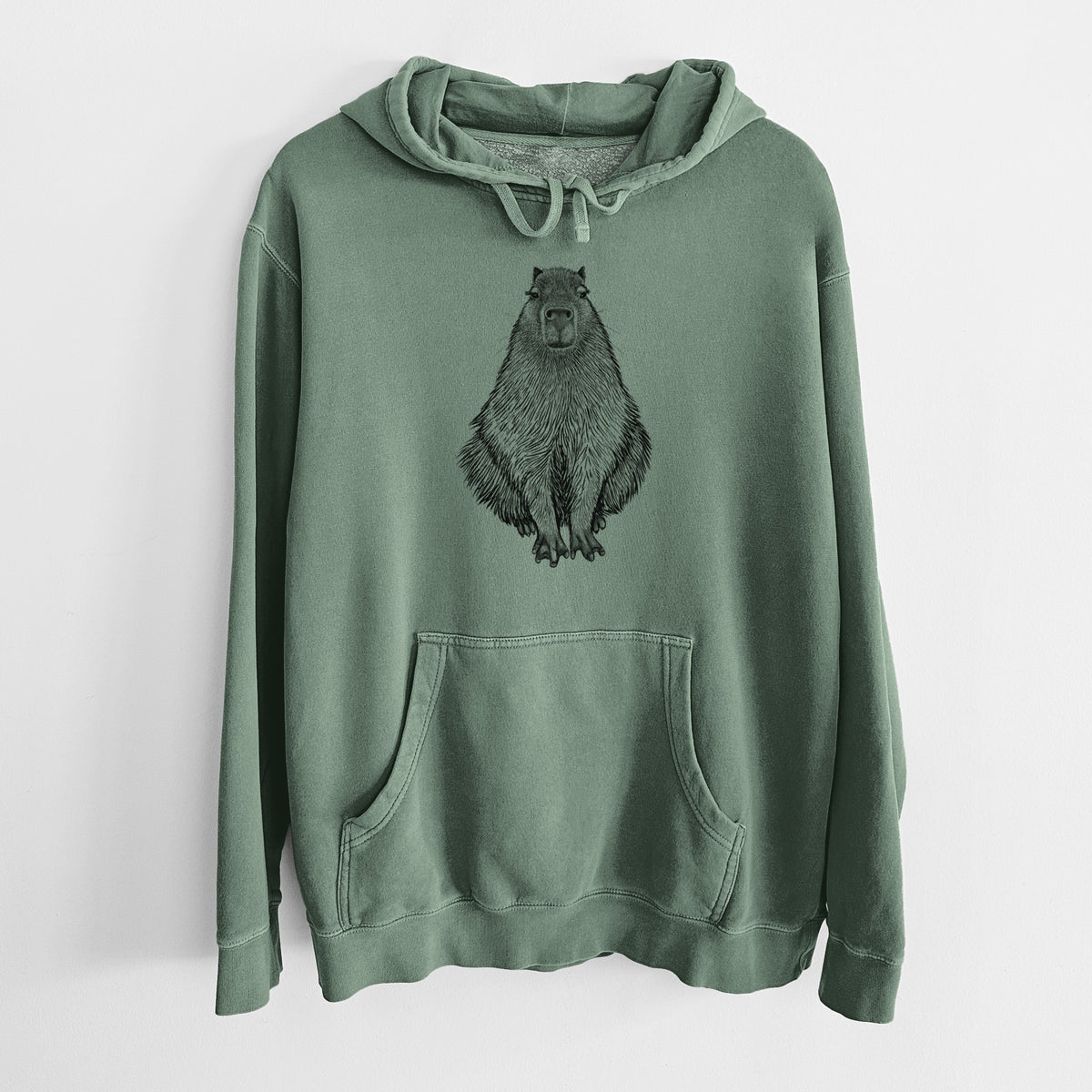 Alpine green pigment dyed hoodie laid flat, printed with a detailed black ink illustration of a capybara sitting and facing forward.