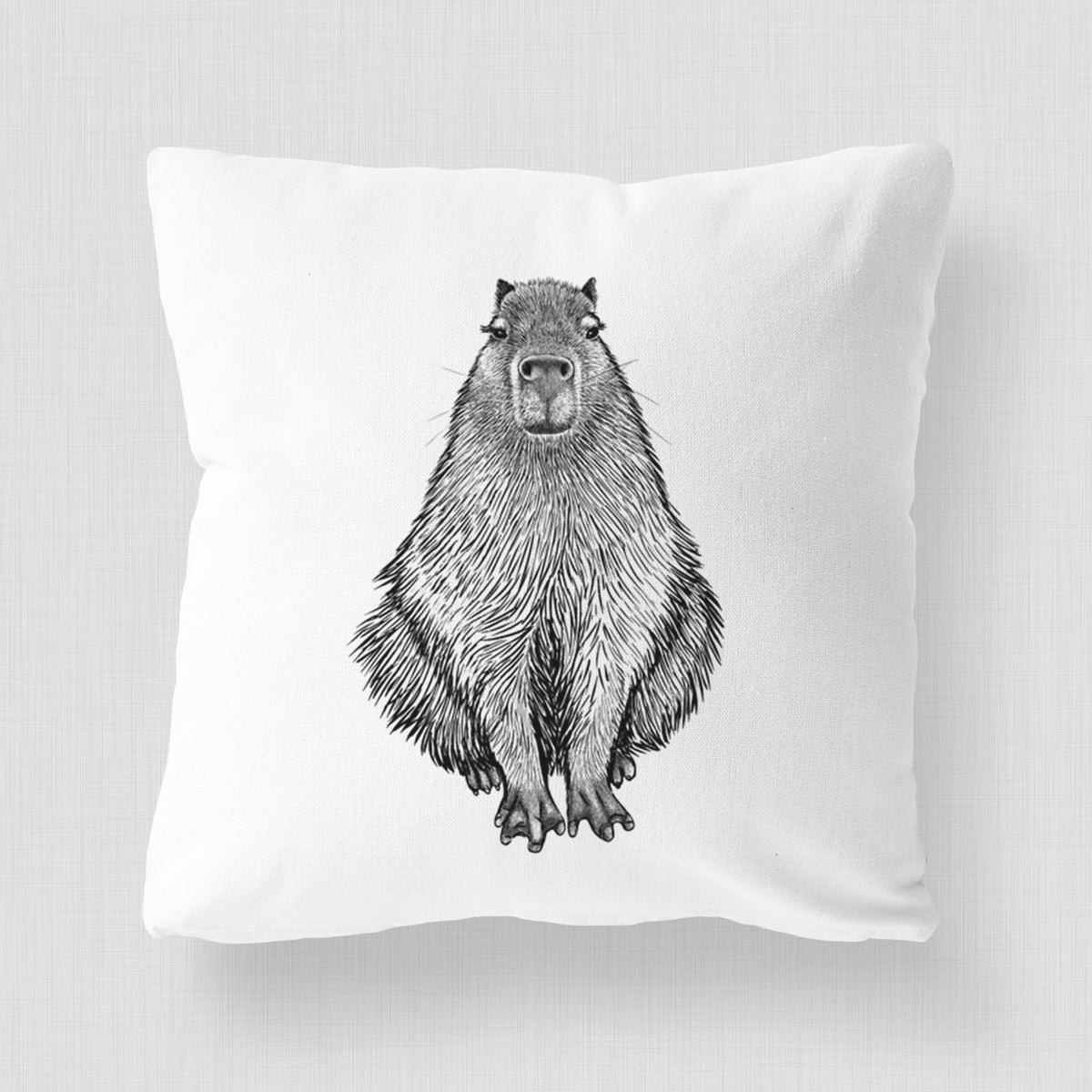 White pillow cover printed with a detailed black ink illustration of a capybara sitting and facing forward.