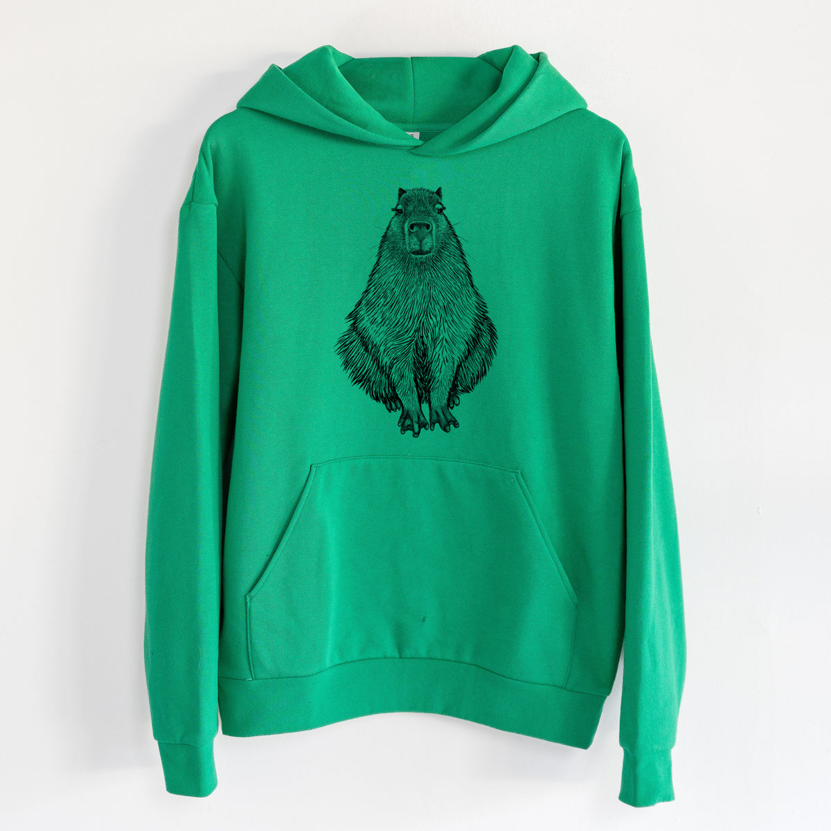Capybara - Hydrochoerus hydrochaeris - Statement Midweight Hoodie in Kelly Green, hanging on a white wall, with a front kangaroo pocket and no drawcords.