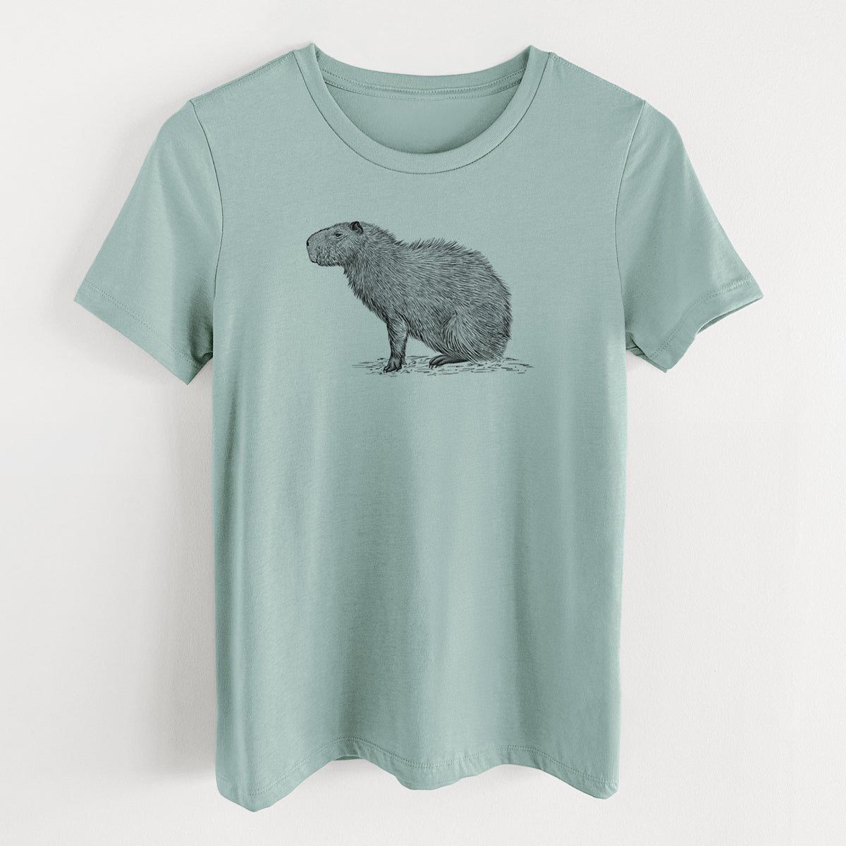 Dusty blue women's relaxed fit cotton t-shirt laid flat, printed with a detailed black ink illustration of a capybara standing in profile.