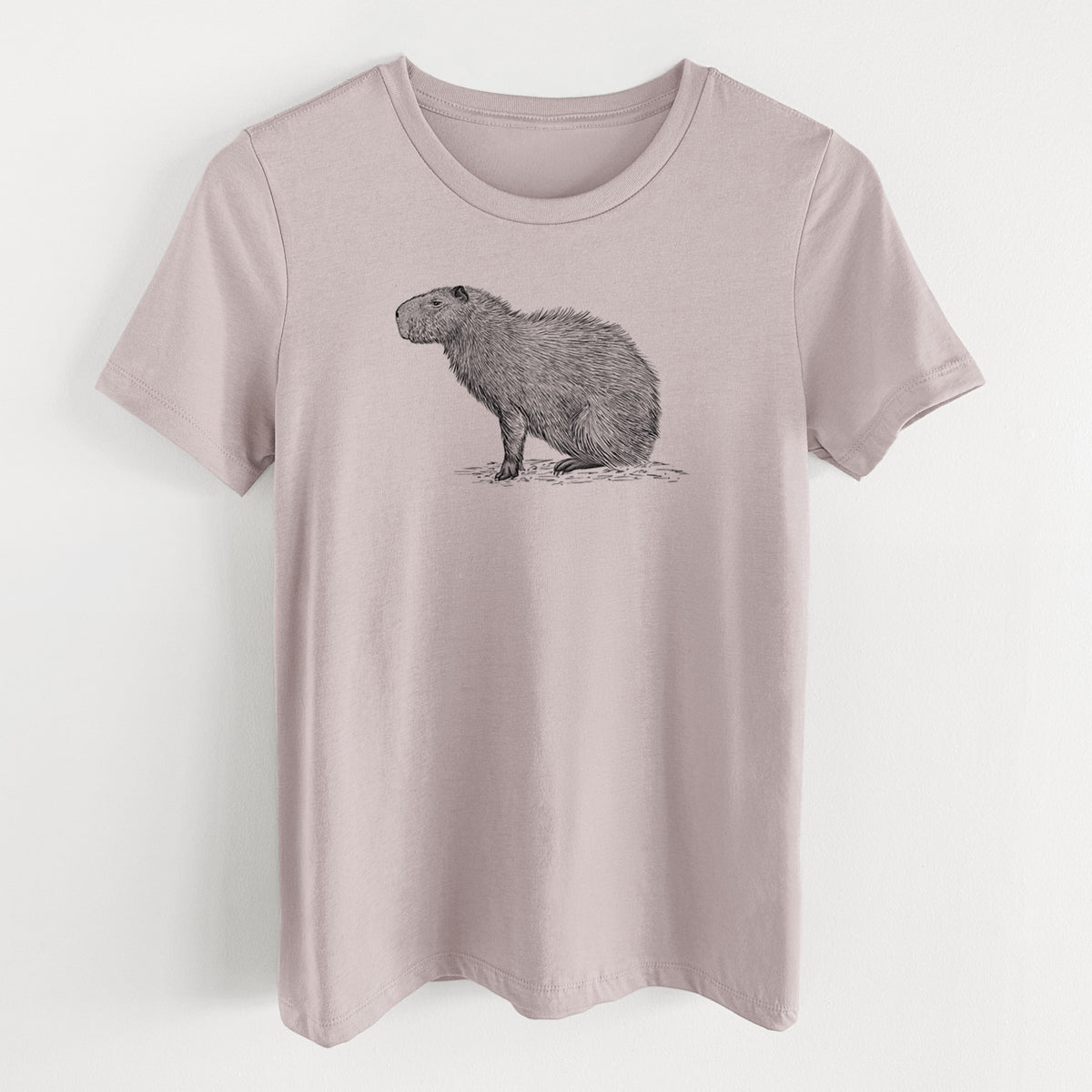 Pink gravel women's relaxed fit cotton t-shirt laid flat, printed with a detailed black ink illustration of a capybara standing in profile.