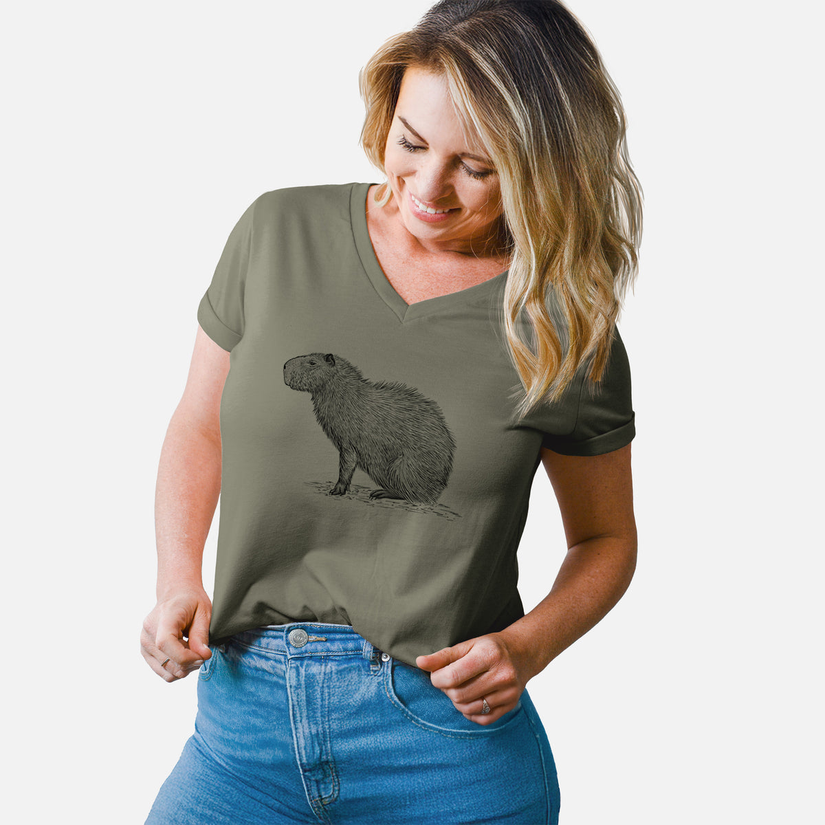 Woman wearing a military green women's relaxed fit cotton V-neck t-shirt printed with a detailed black ink illustration of a capybara standing in profile.