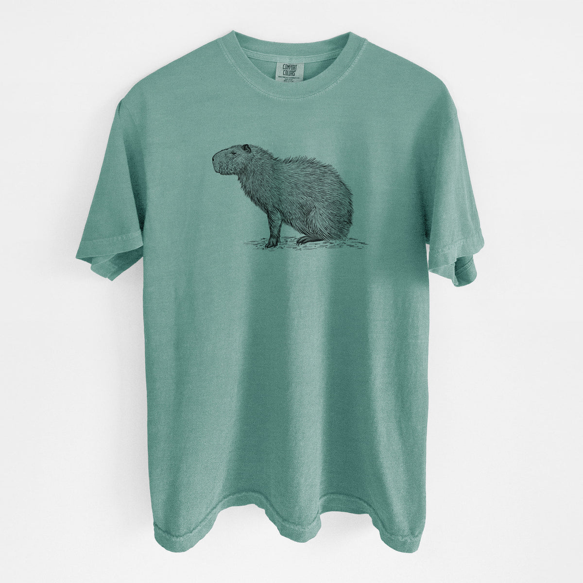 Reef green Comfort Colors t-shirt laid flat, printed with a detailed black ink illustration of a capybara standing in profile.
