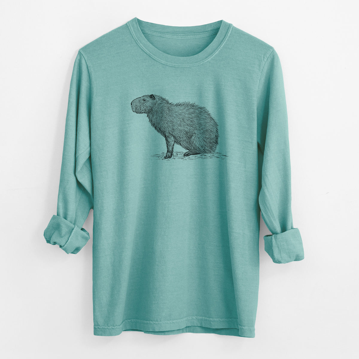 Reef green Comfort Colors long sleeve shirt laid flat with the cuffs rolled, printed with a detailed black ink illustration of a capybara standing in profile.
