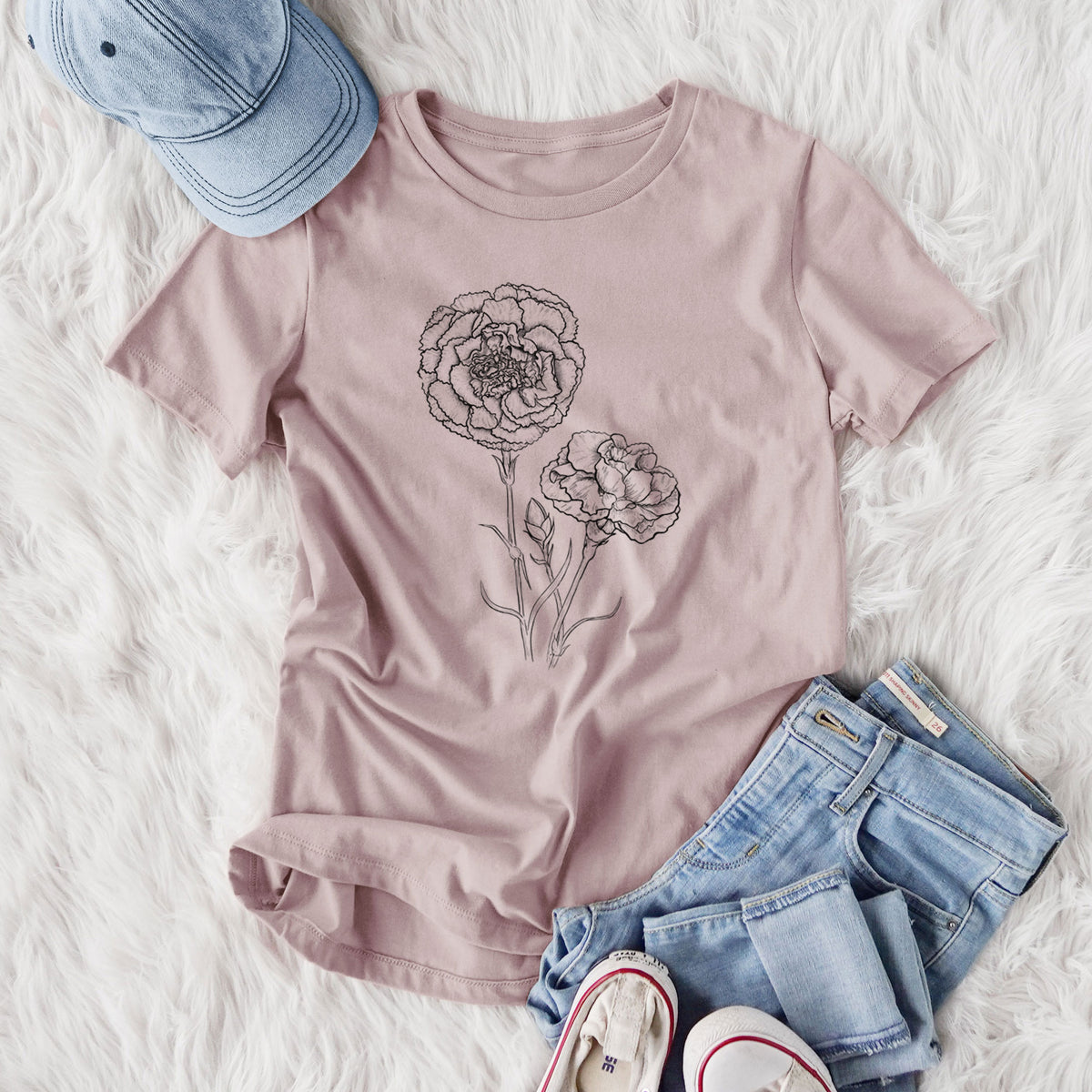 Women's relaxed fit cotton t-shirt printed with a black ink line drawing of carnation flowers on stems, styled flat on a white faux fur rug with jeans.