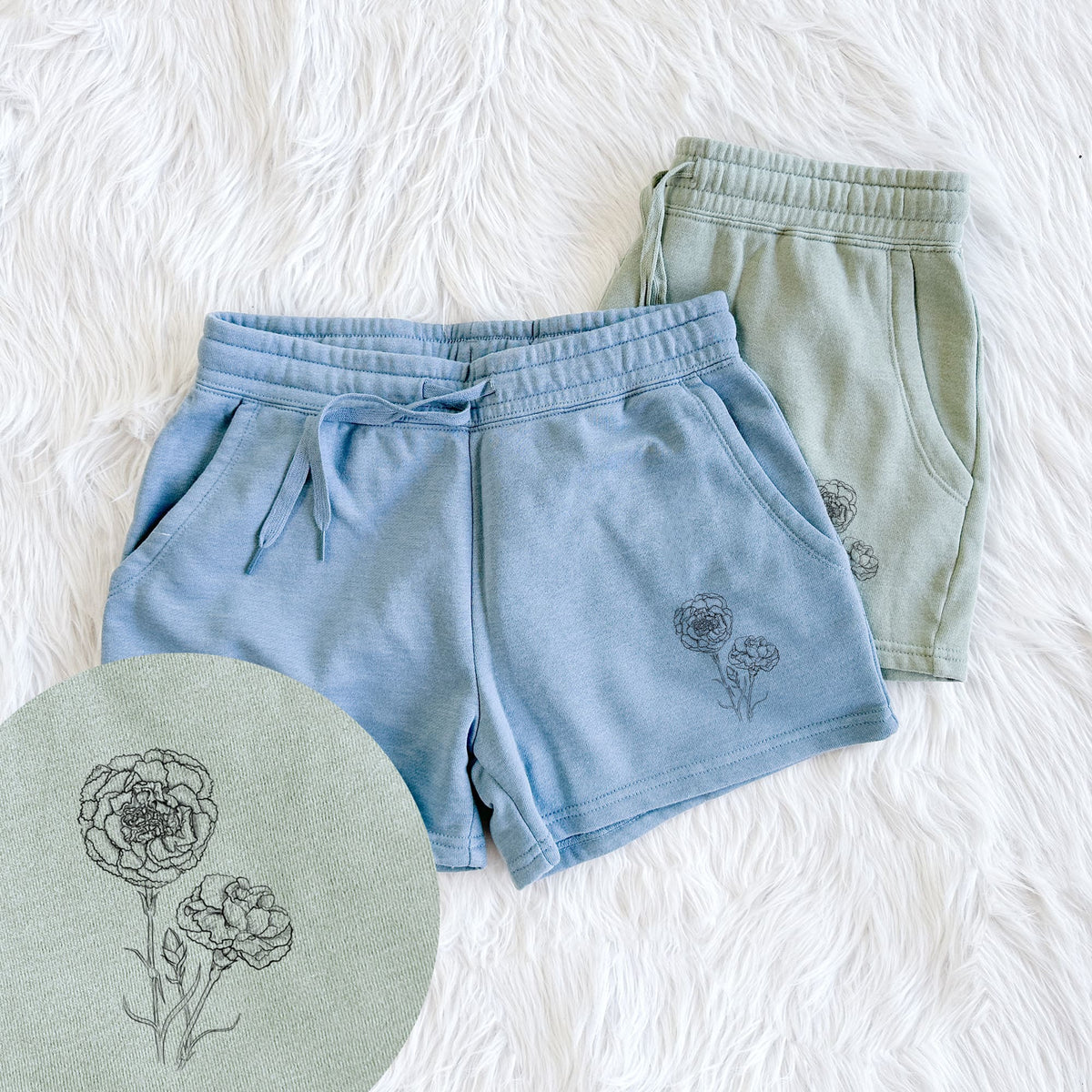 Two pairs of Cali Wave shorts in different colors printed with a black ink line drawing of carnation flowers on stems, with a close-up of the print.