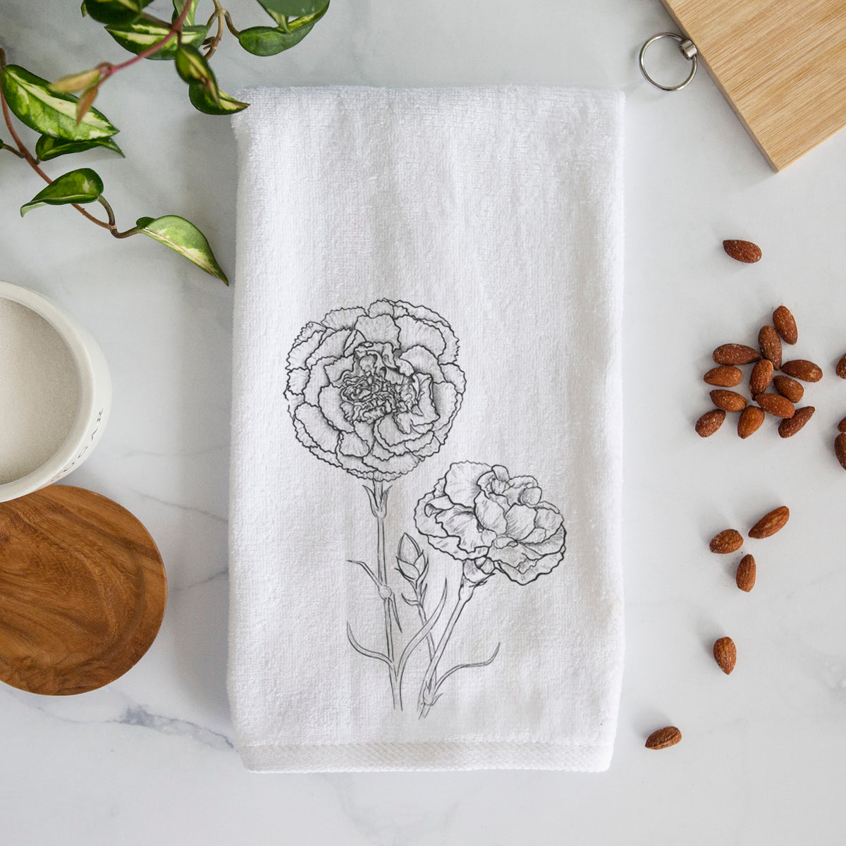 White hand towel printed with a black ink line drawing of carnation flowers on stems.