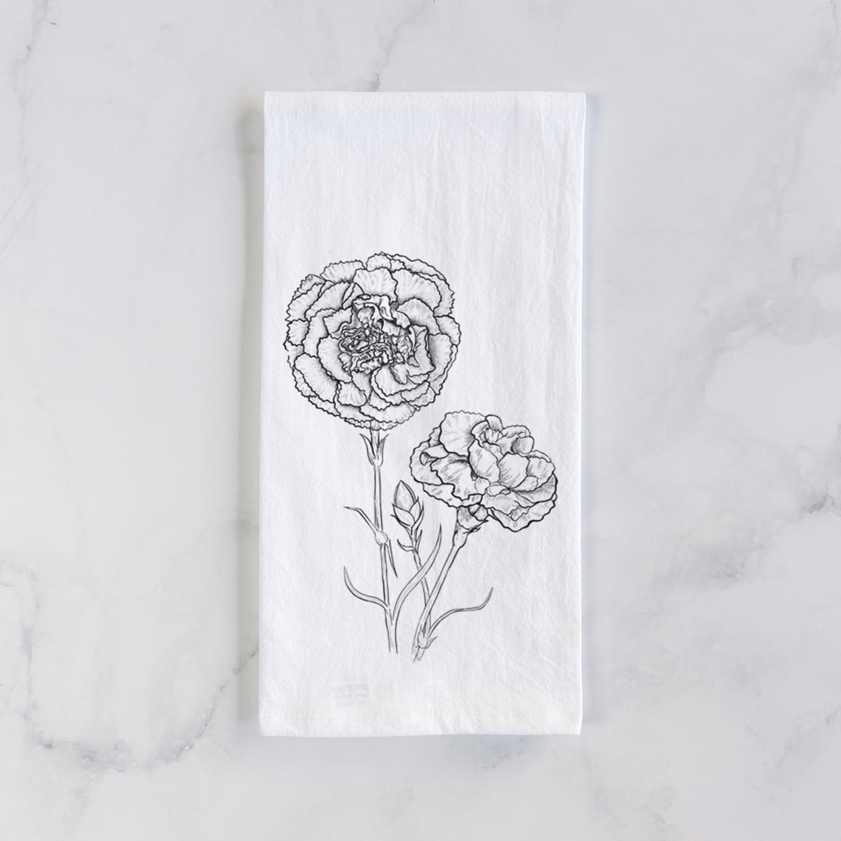 White cotton tea towel laid flat on marble, printed with a black ink line drawing of carnation flowers on stems.