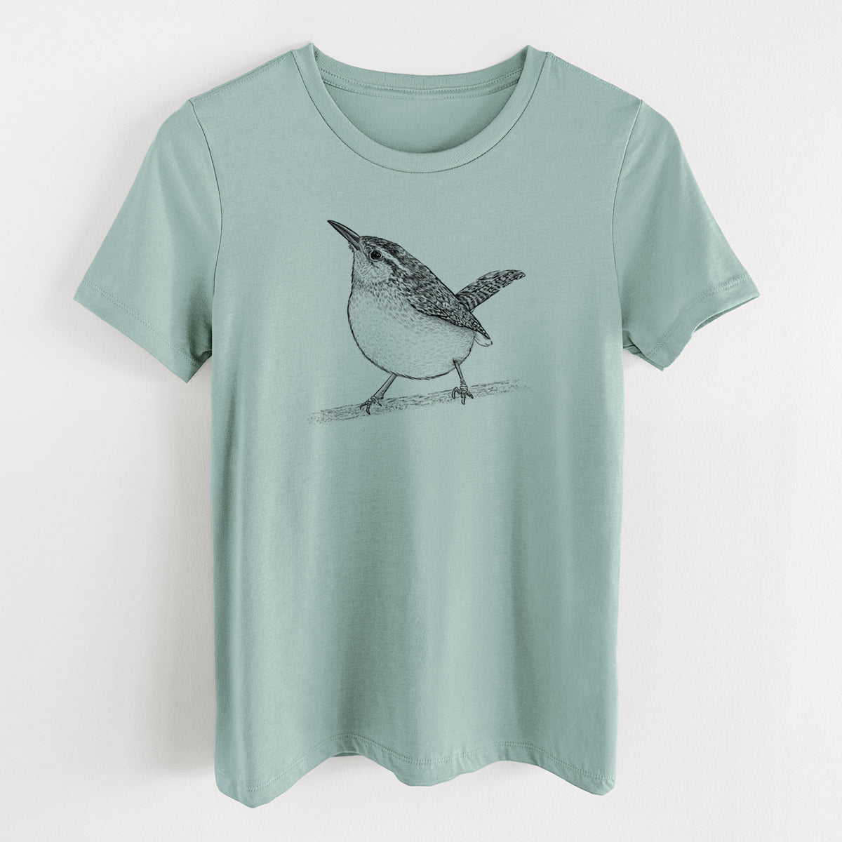 Dusty blue women's relaxed fit cotton t-shirt laid flat, printed with a detailed black ink sketch of a Carolina wren perched on a branch with its tail raised.