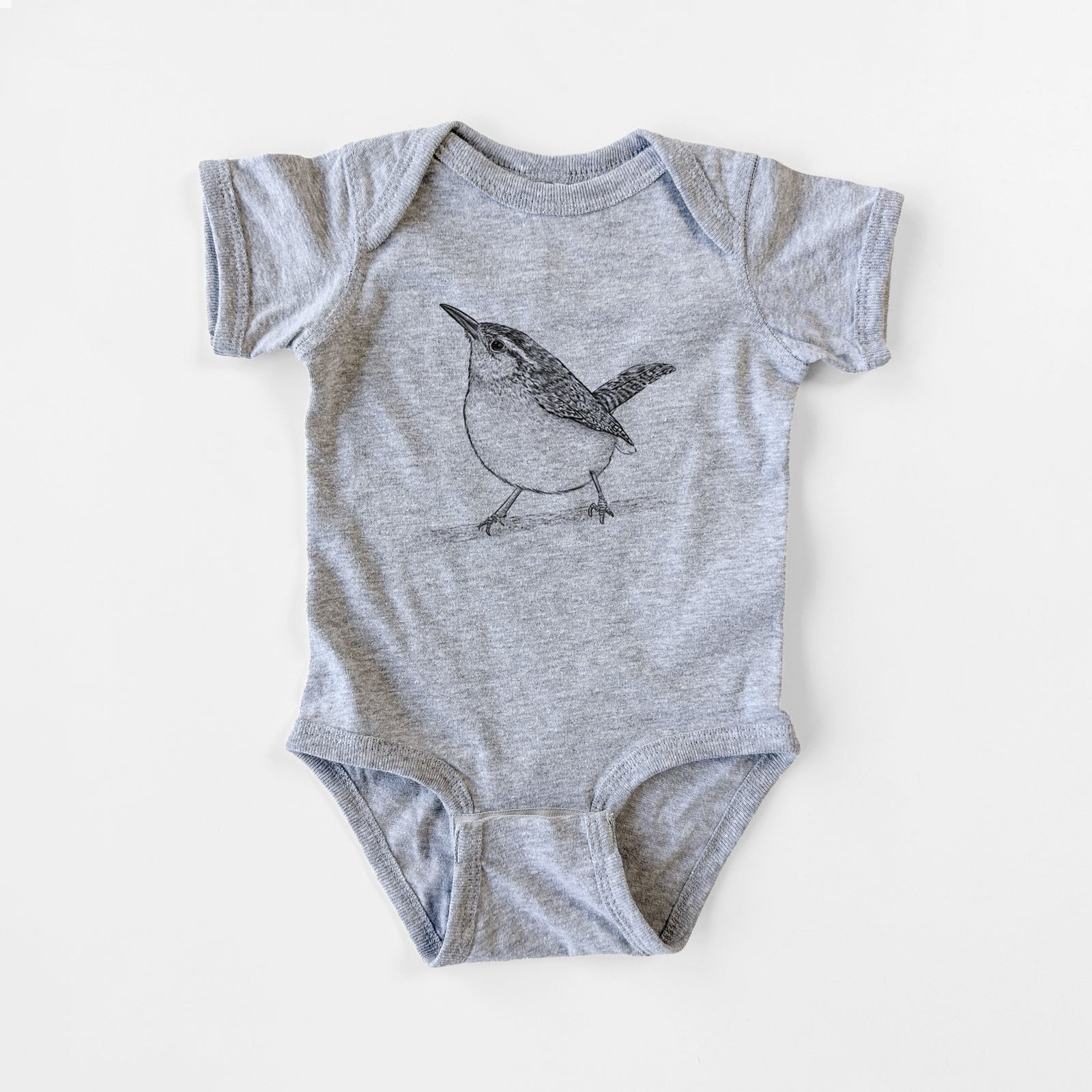 Grey baby bodysuit laid flat, printed with a detailed black ink sketch of a Carolina wren perched on a branch with its tail raised.