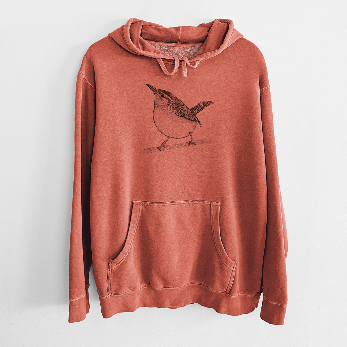 Amber orange pigment dyed hoodie laid flat, printed with a detailed black ink sketch of a Carolina wren perched on a branch with its tail raised.