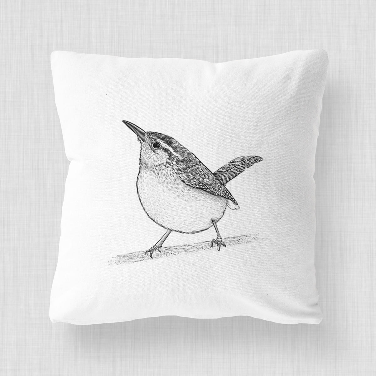 White pillow cover printed with a detailed black ink sketch of a Carolina wren perched on a branch with its tail raised.