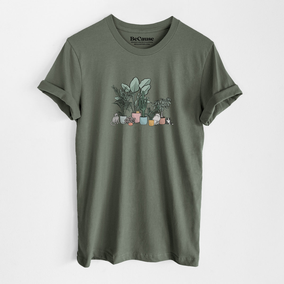 Military green lightweight cotton t-shirt laid flat, printed with a full-color illustration of cats lounging among potted houseplants.