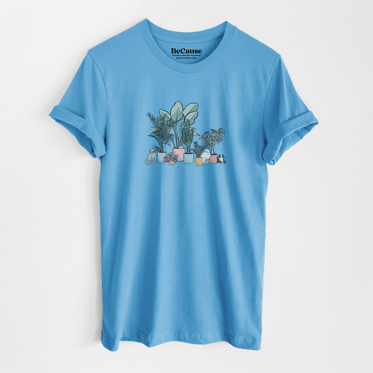 Ocean blue lightweight cotton t-shirt laid flat, printed with a full-color illustration of cats lounging among potted houseplants.