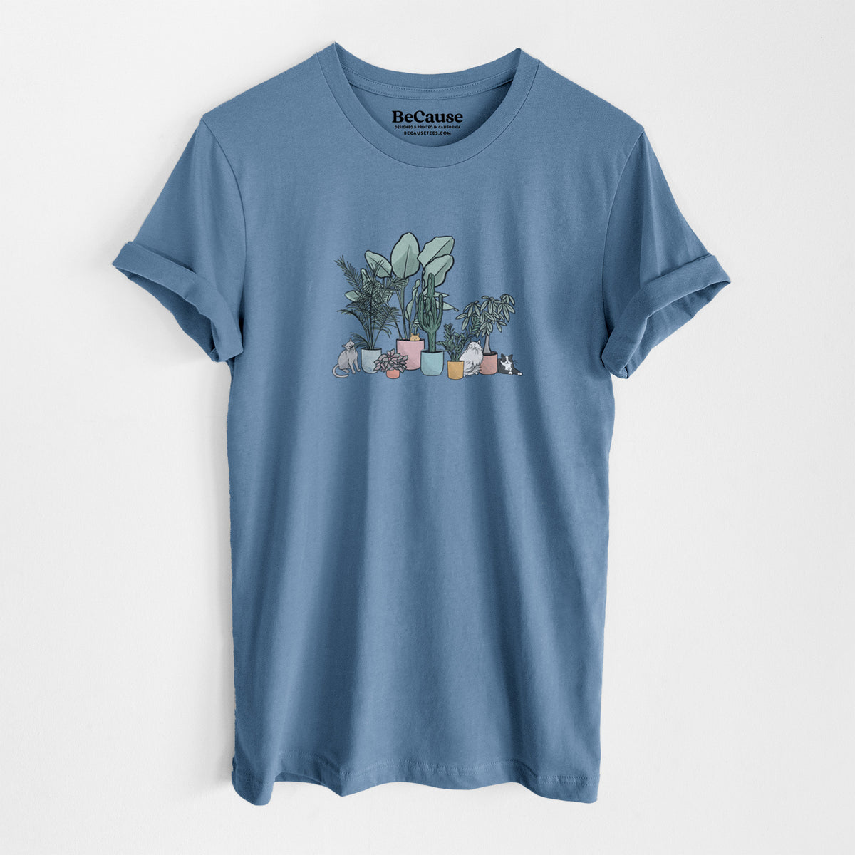 Steel blue lightweight cotton t-shirt laid flat, printed with a full-color illustration of cats lounging among potted houseplants.