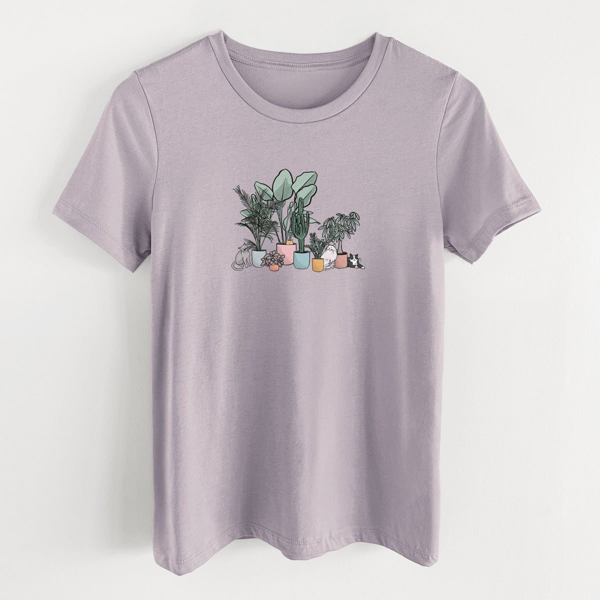 Light violet women's relaxed fit cotton t-shirt laid flat, printed with a full-color illustration of cats lounging among potted houseplants.