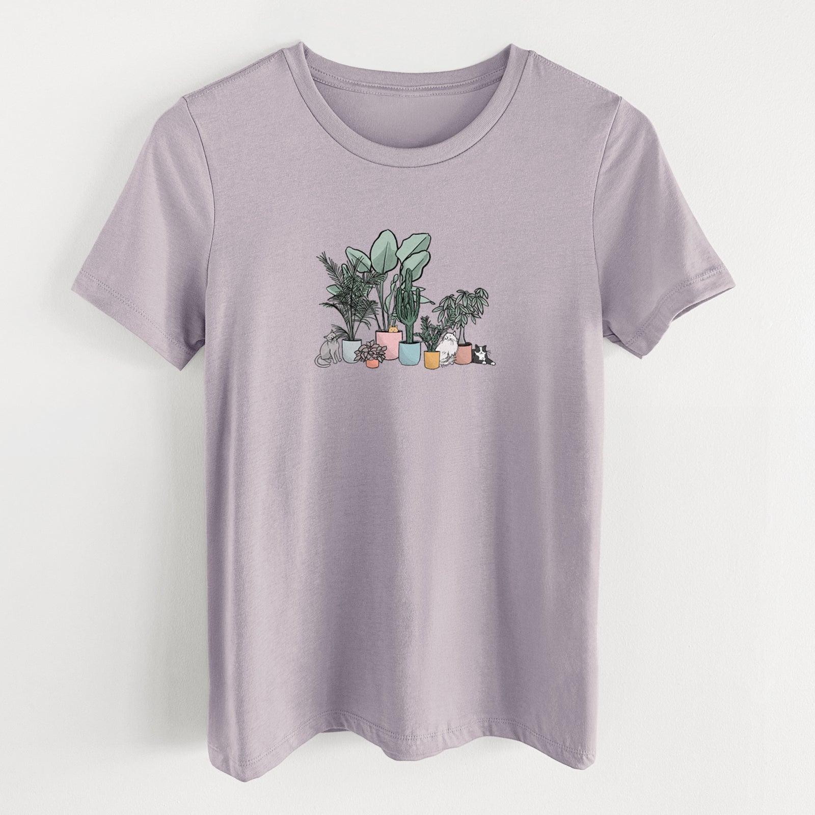 Light violet women's relaxed fit cotton t-shirt laid flat, printed with a full-color illustration of cats lounging among potted houseplants.