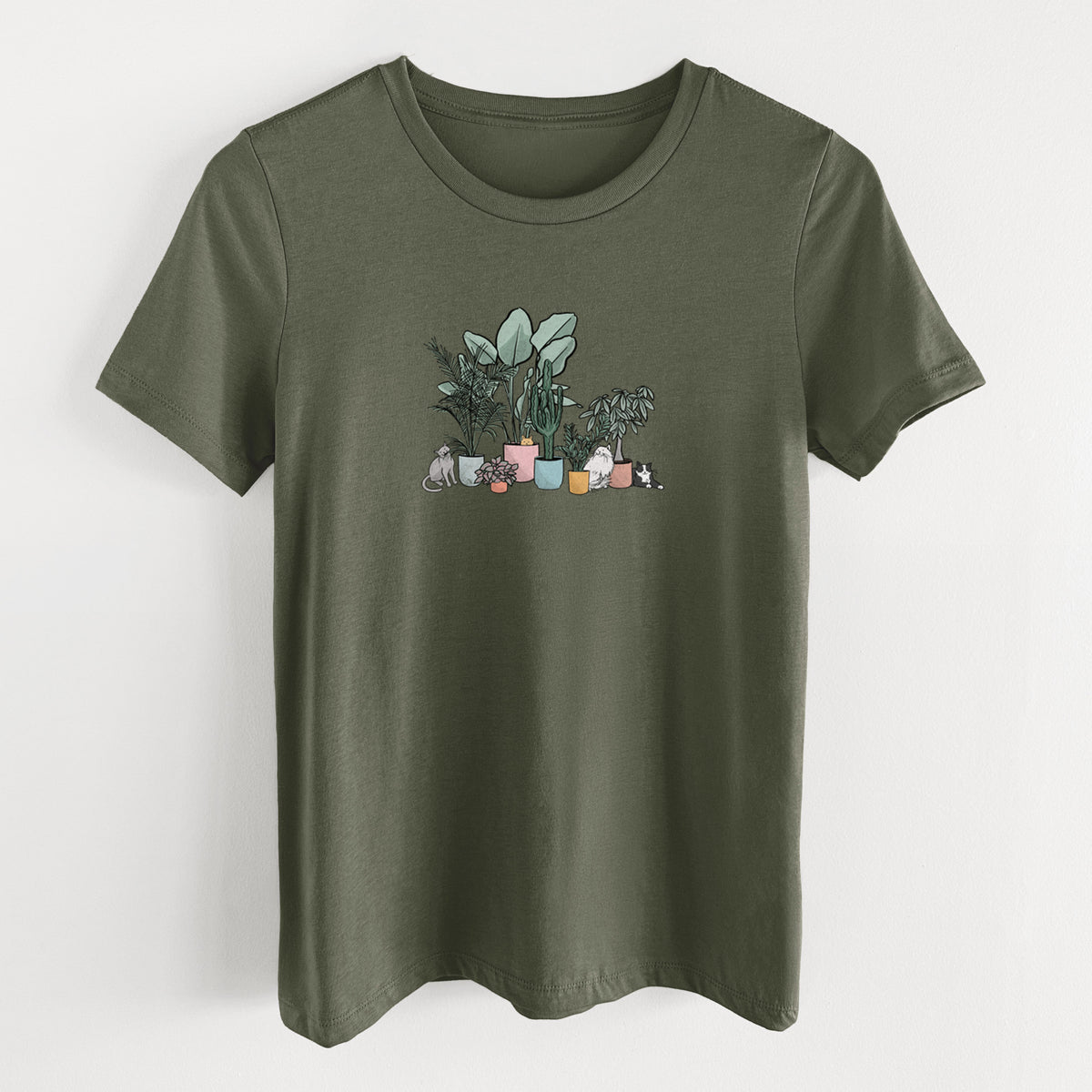 Military green women's relaxed fit cotton t-shirt laid flat, printed with a full-color illustration of cats lounging among potted houseplants.