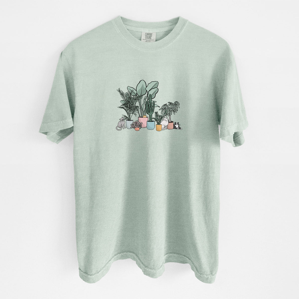 Bay green Comfort Colors t-shirt laid flat, printed with a full-color illustration of cats lounging among potted houseplants.