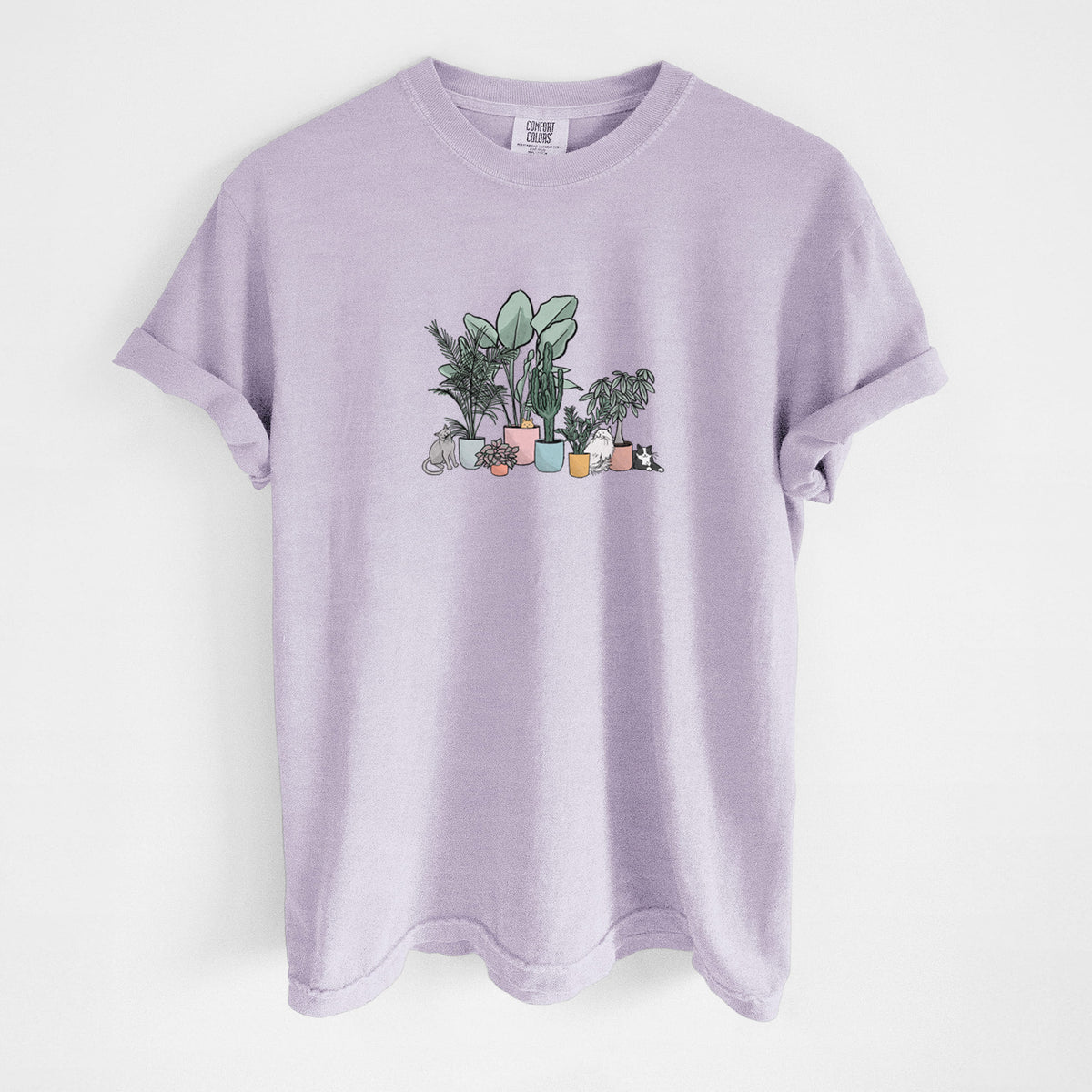 Orchid purple Comfort Colors t-shirt laid flat, printed with a full-color illustration of cats lounging among potted houseplants.