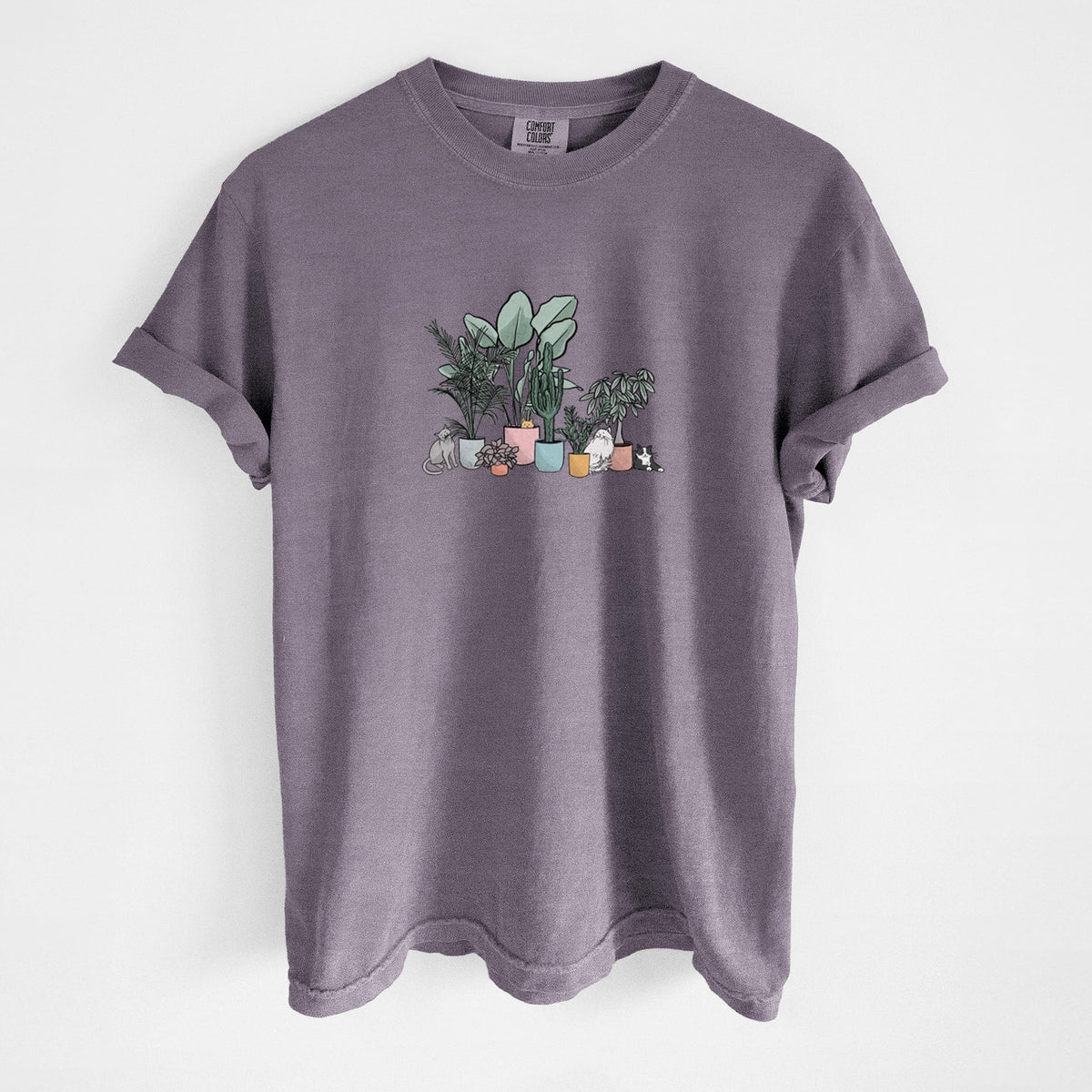 Wine red Comfort Colors t-shirt laid flat, printed with a full-color illustration of cats lounging among potted houseplants.