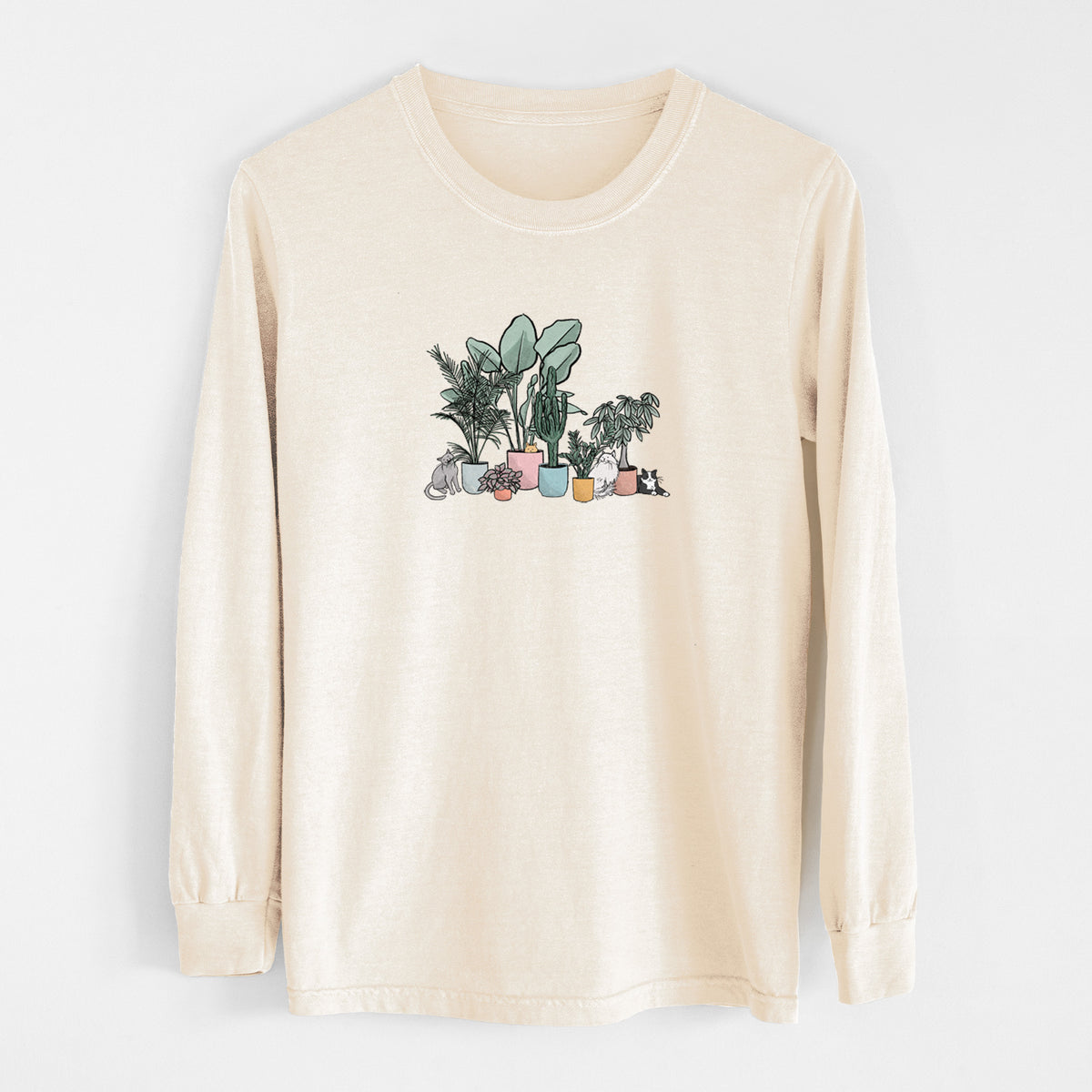 Ivory Comfort Colors long sleeve shirt laid flat, printed with a full-color illustration of cats lounging among potted houseplants.
