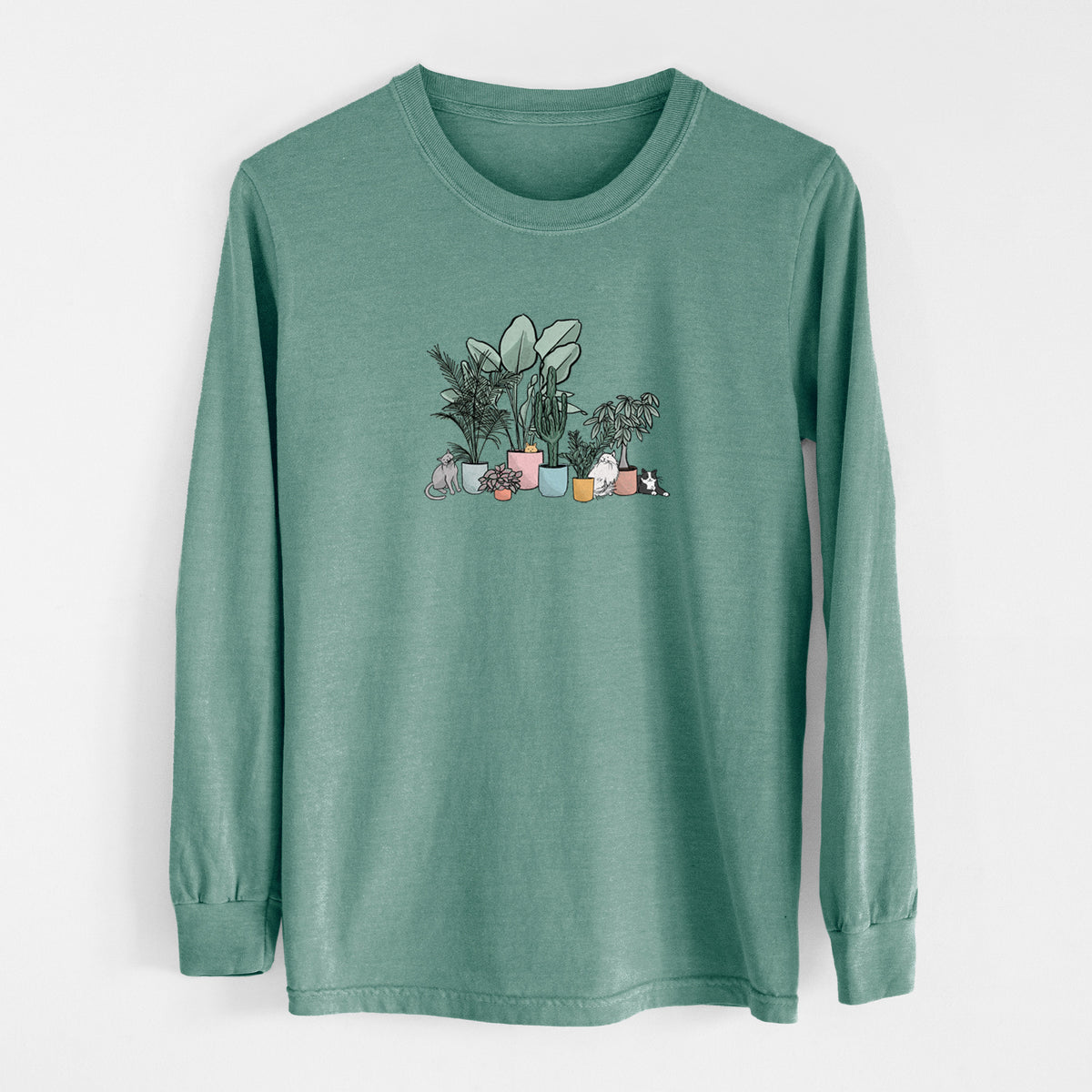 Pine green Comfort Colors long sleeve shirt laid flat, printed with a full-color illustration of cats lounging among potted houseplants.