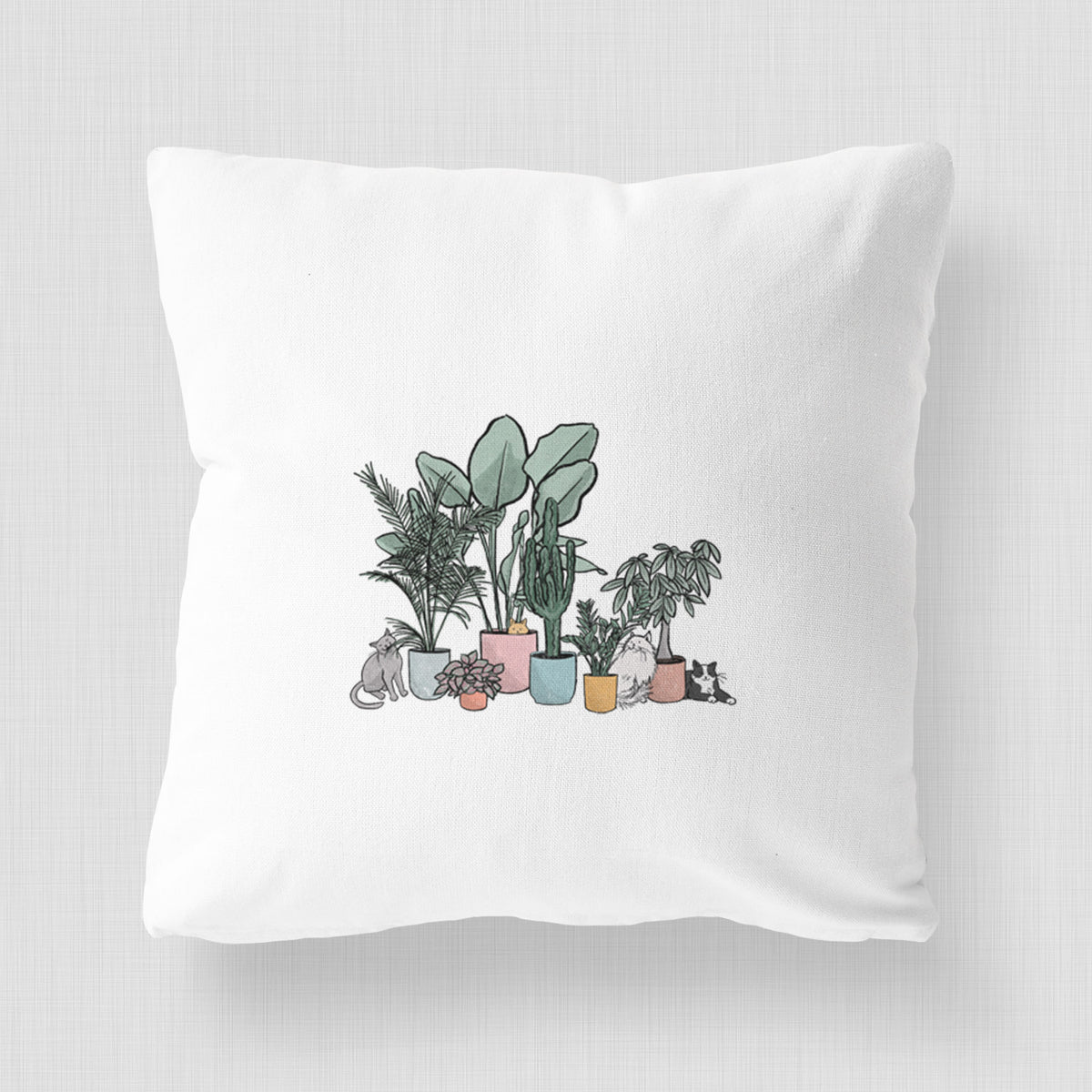 White pillow cover printed with a full-color illustration of cats lounging among potted houseplants.