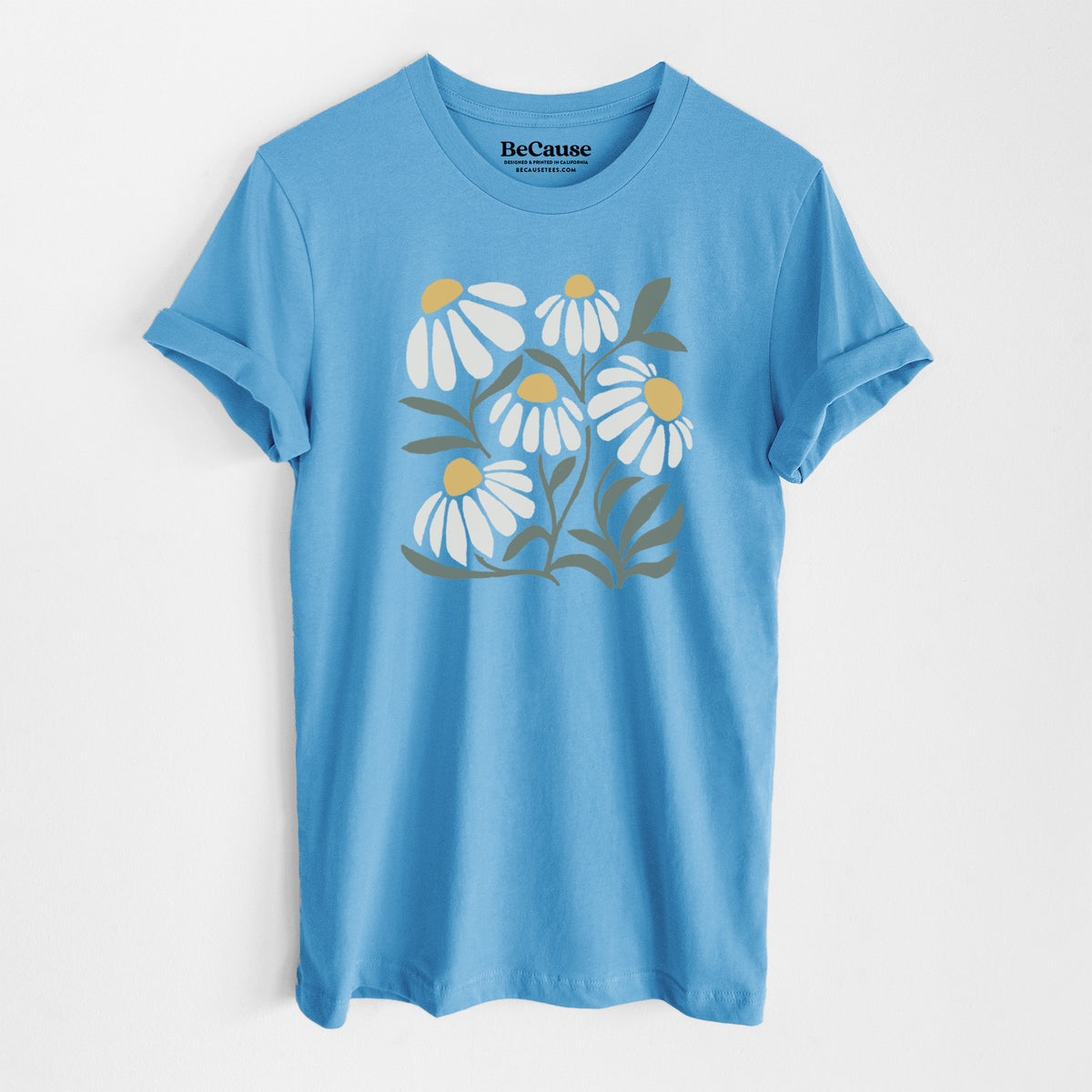 Ocean blue lightweight cotton t-shirt laid flat, printed with a soft full-color illustration of white chamomile flowers and green leaves.
