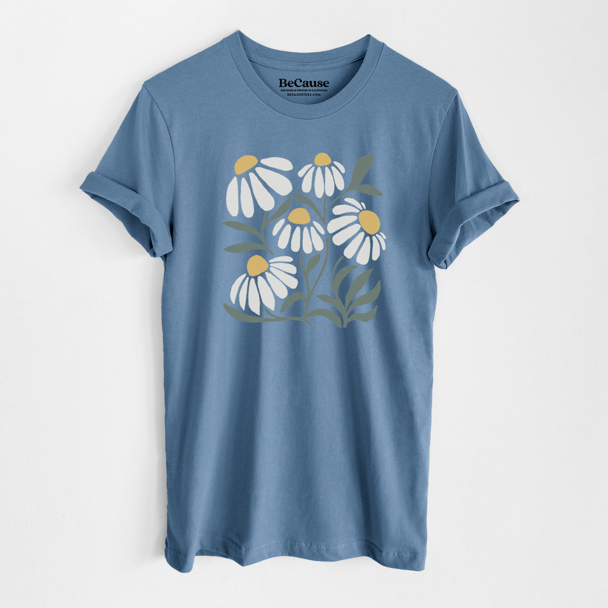Steel blue lightweight cotton t-shirt laid flat, printed with a soft full-color illustration of white chamomile flowers and green leaves.