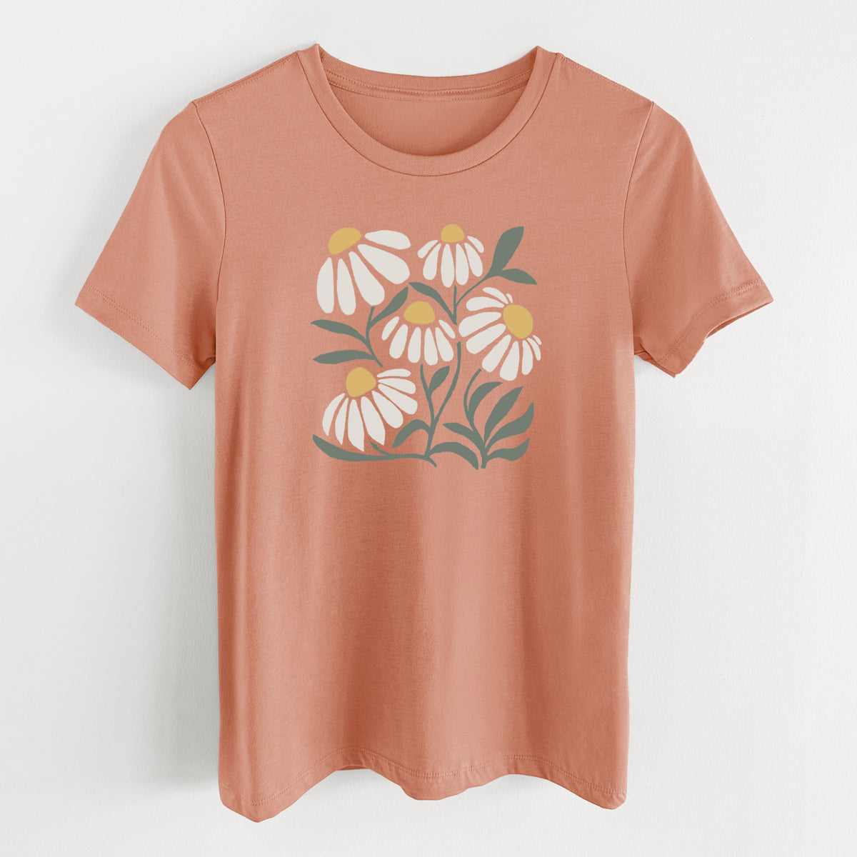 Terracotta orange women's relaxed fit cotton t-shirt laid flat, printed with a soft full-color illustration of white chamomile flowers and green leaves.