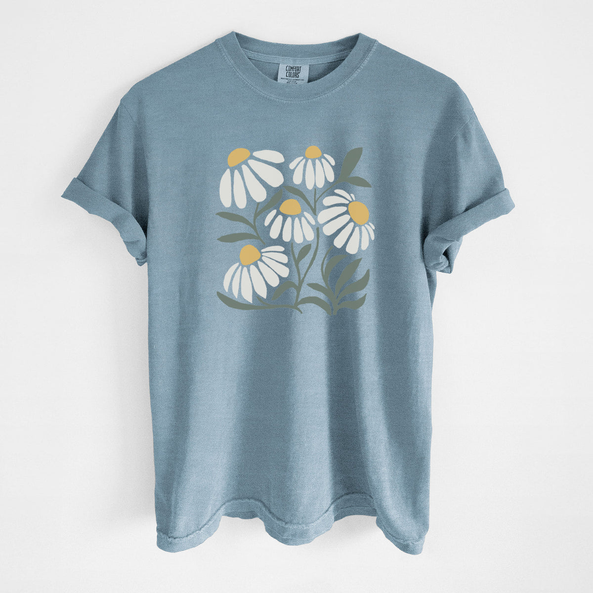 Steel blue Comfort Colors t-shirt laid flat, printed with a soft full-color illustration of white chamomile flowers and green leaves.
