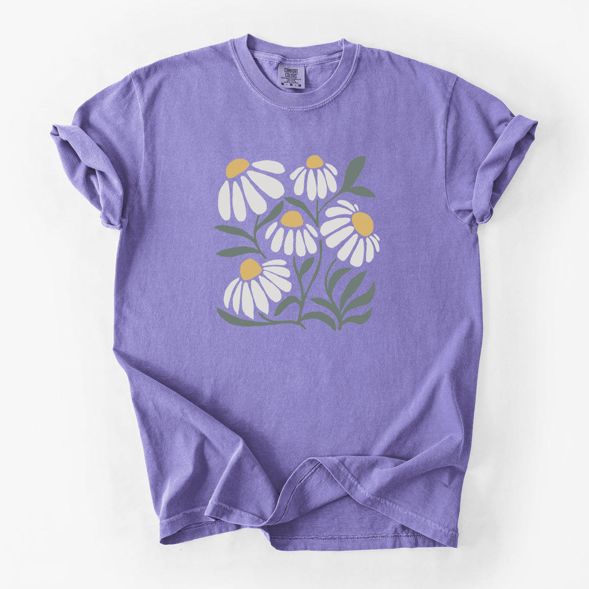 Violet purple Comfort Colors t-shirt laid flat, printed with a soft full-color illustration of white chamomile flowers and green leaves.