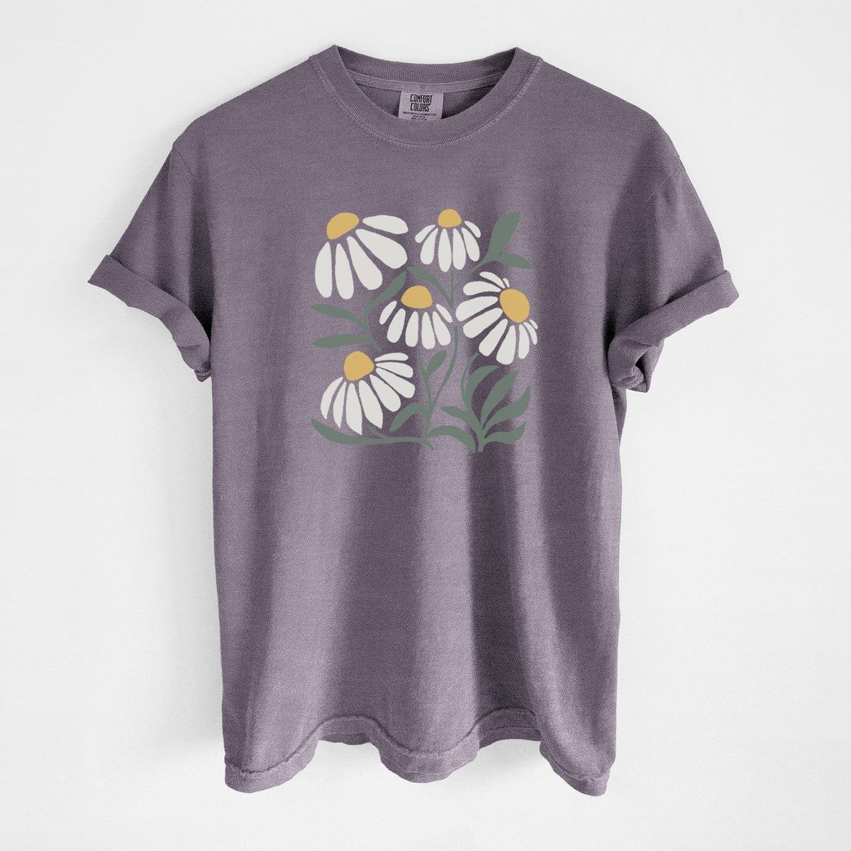 Wine red Comfort Colors t-shirt laid flat, printed with a soft full-color illustration of white chamomile flowers and green leaves.