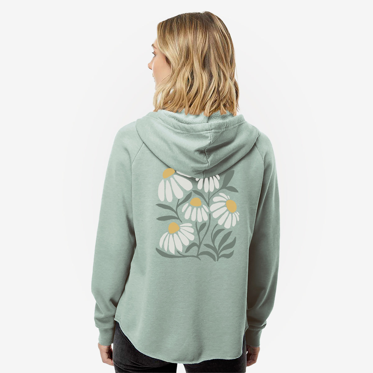 Woman wearing a sage green women's Cali Wave zip-up sweatshirt printed with a soft full-color illustration of white chamomile flowers and green leaves, seen from behind.