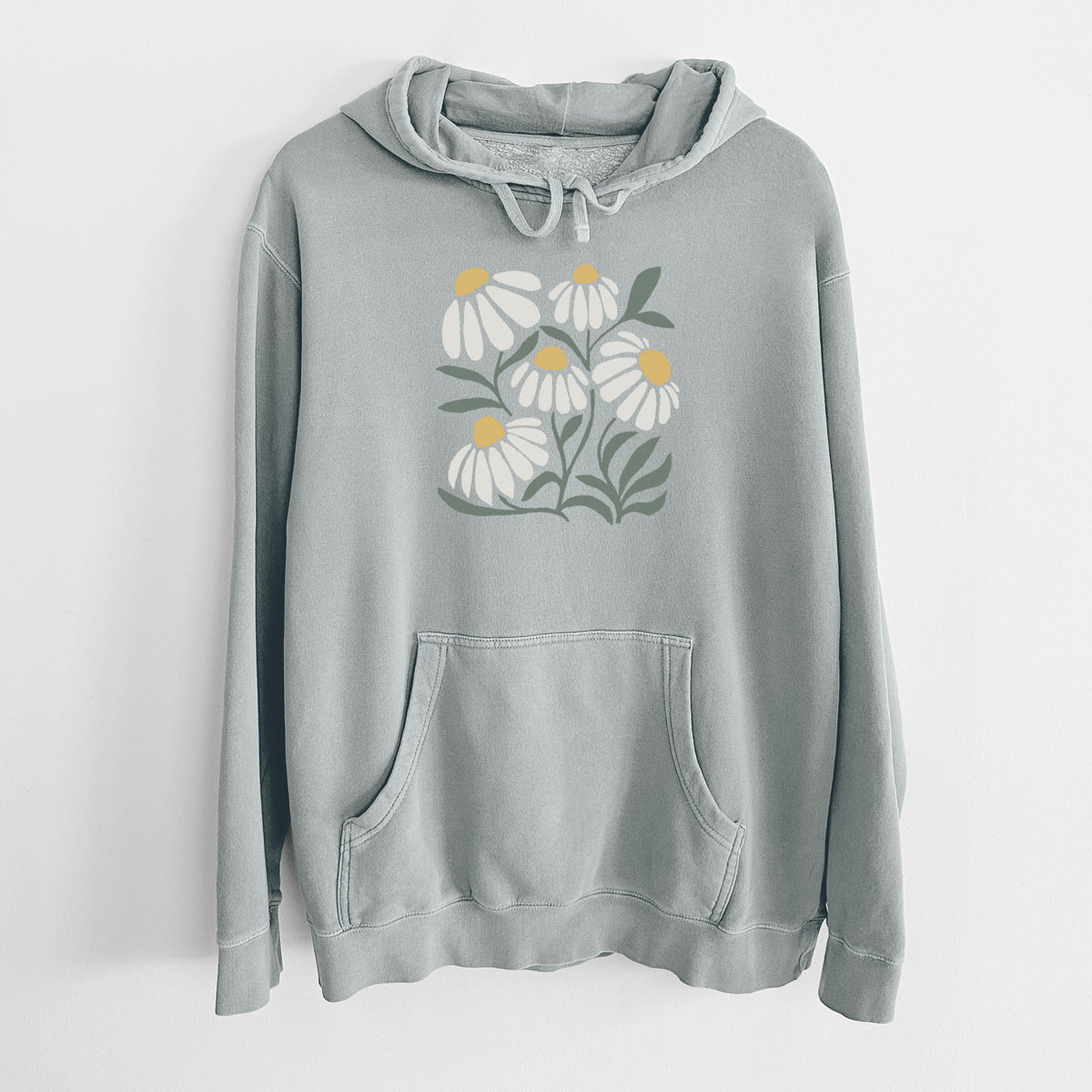 Sage green pigment dyed hoodie laid flat, printed with a soft full-color illustration of white chamomile flowers and green leaves.
