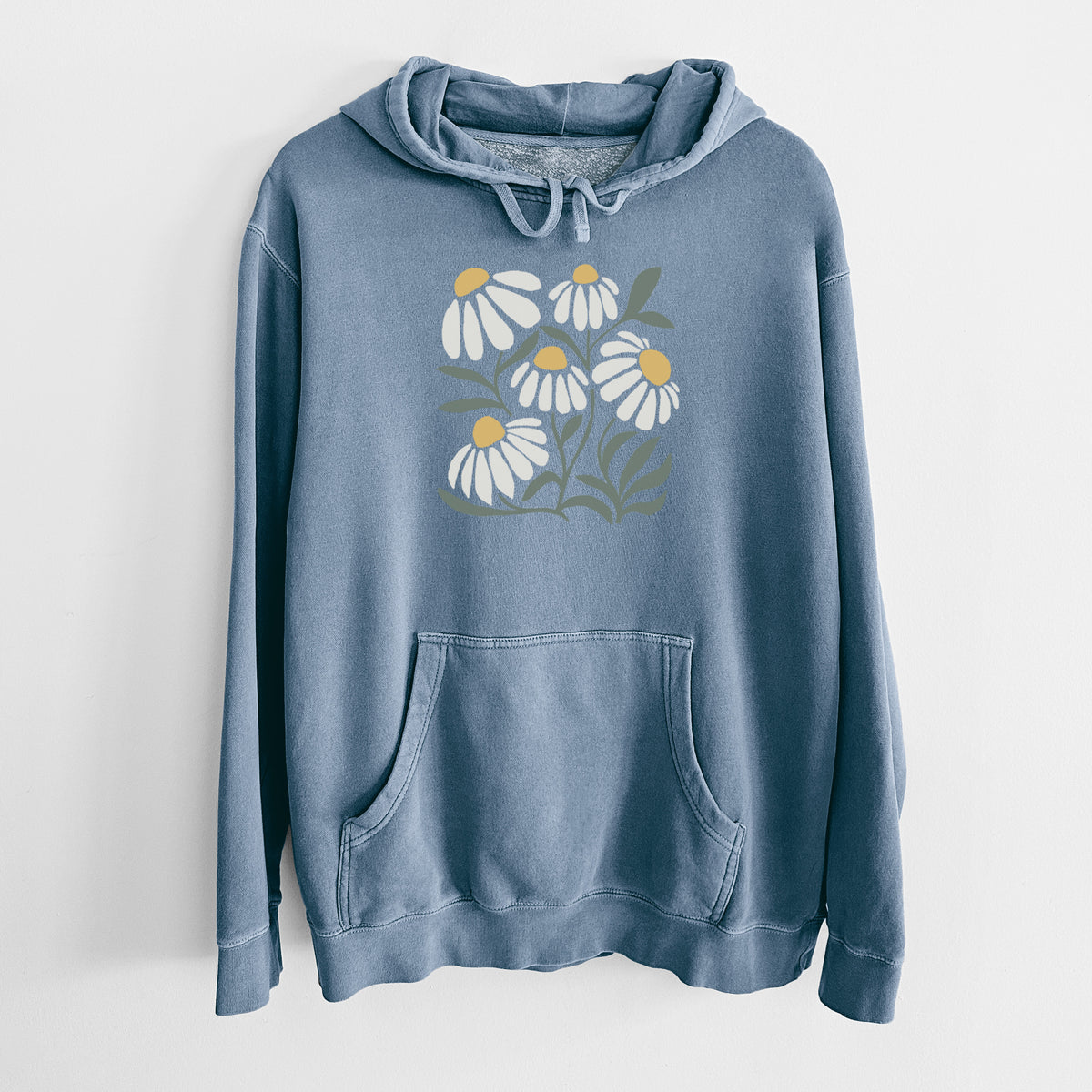 Slate blue pigment dyed hoodie laid flat, printed with a soft full-color illustration of white chamomile flowers and green leaves.