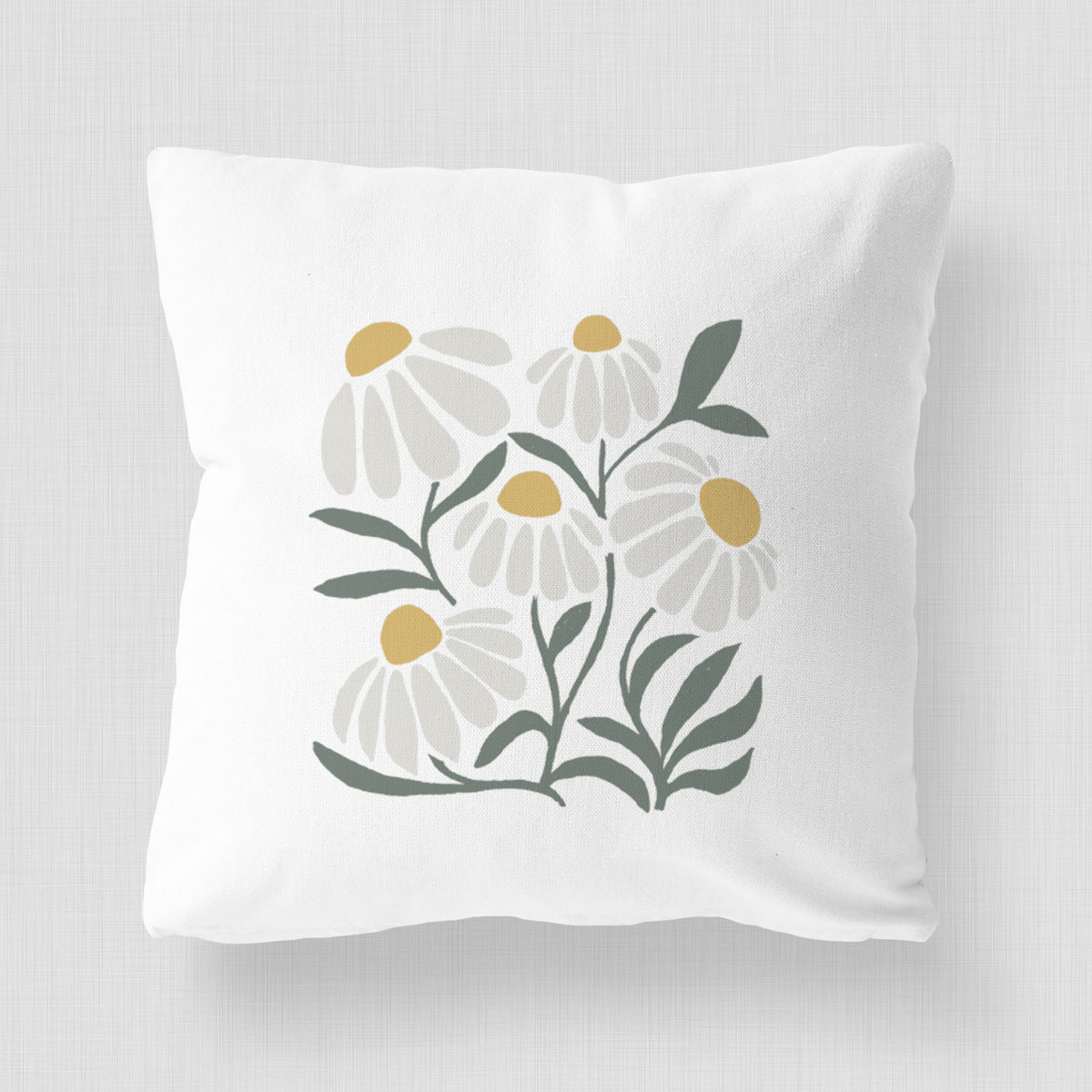 White pillow cover printed with a soft full-color illustration of white chamomile flowers and green leaves.