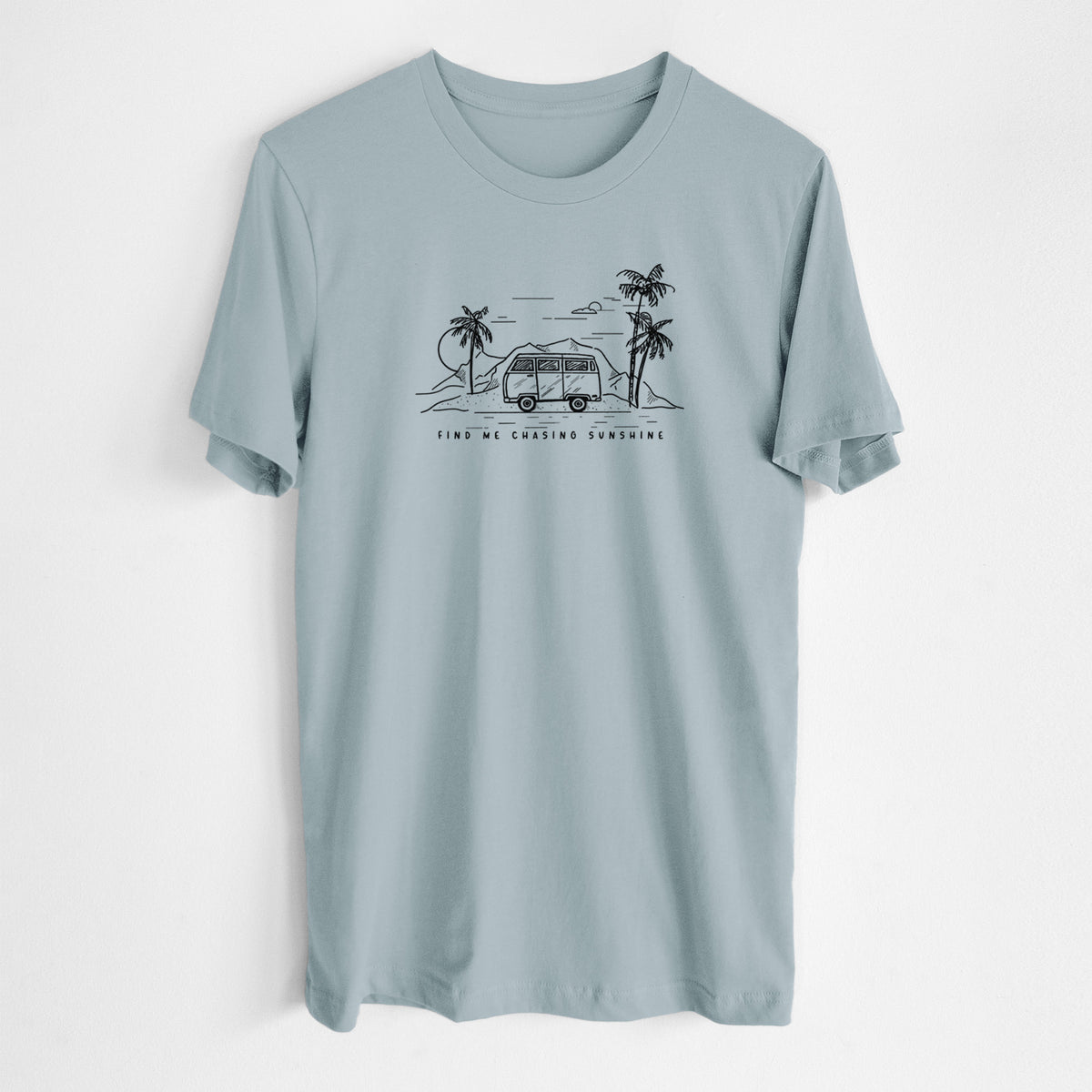 Vintage denim lightweight cotton t-shirt laid flat, printed with a black ink illustration of a camper van under palm trees and the sun, with the words Find Me Chasing Sunshine.