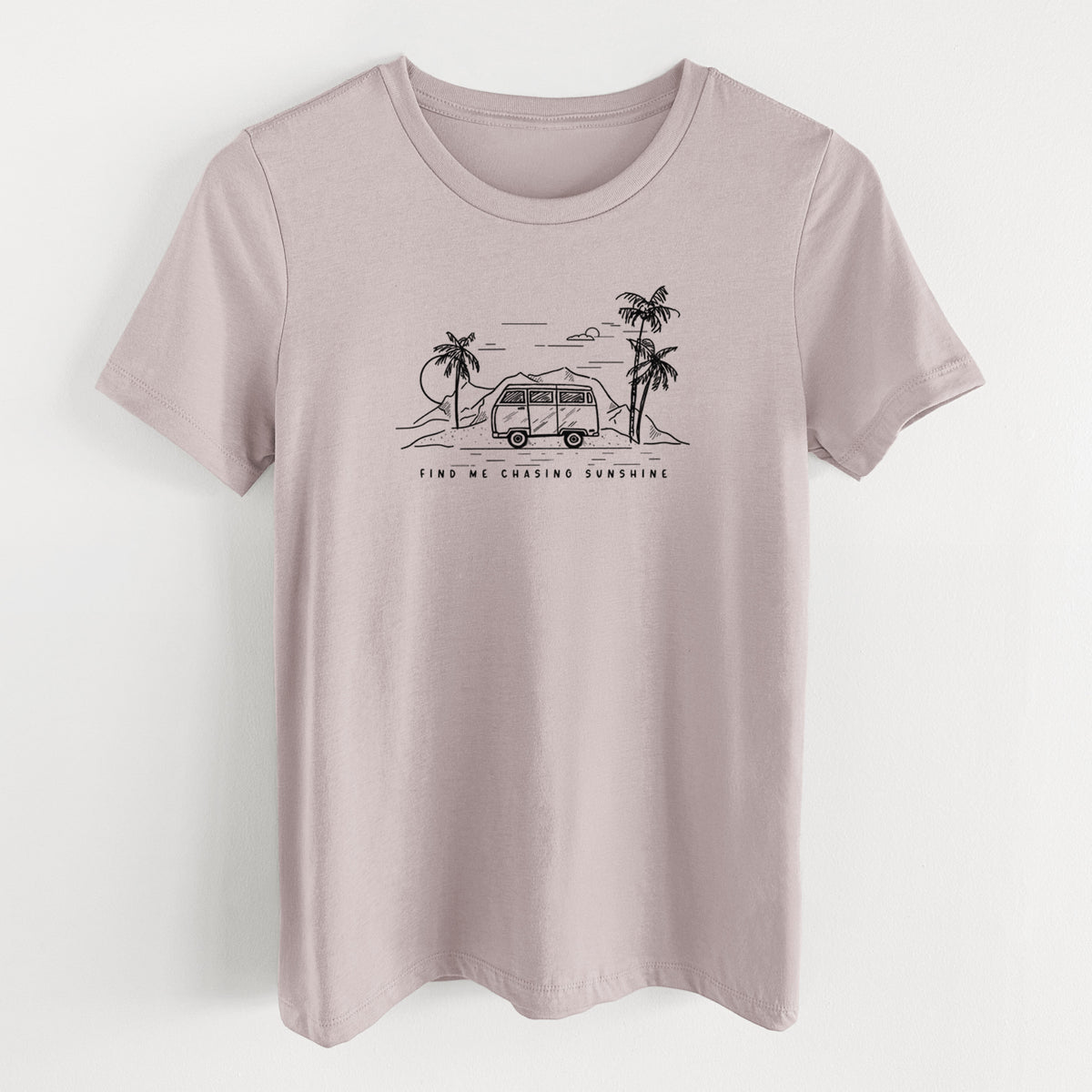 Pink gravel women's relaxed fit cotton t-shirt laid flat, printed with a black ink illustration of a camper van under palm trees and the sun, with the words Find Me Chasing Sunshine.
