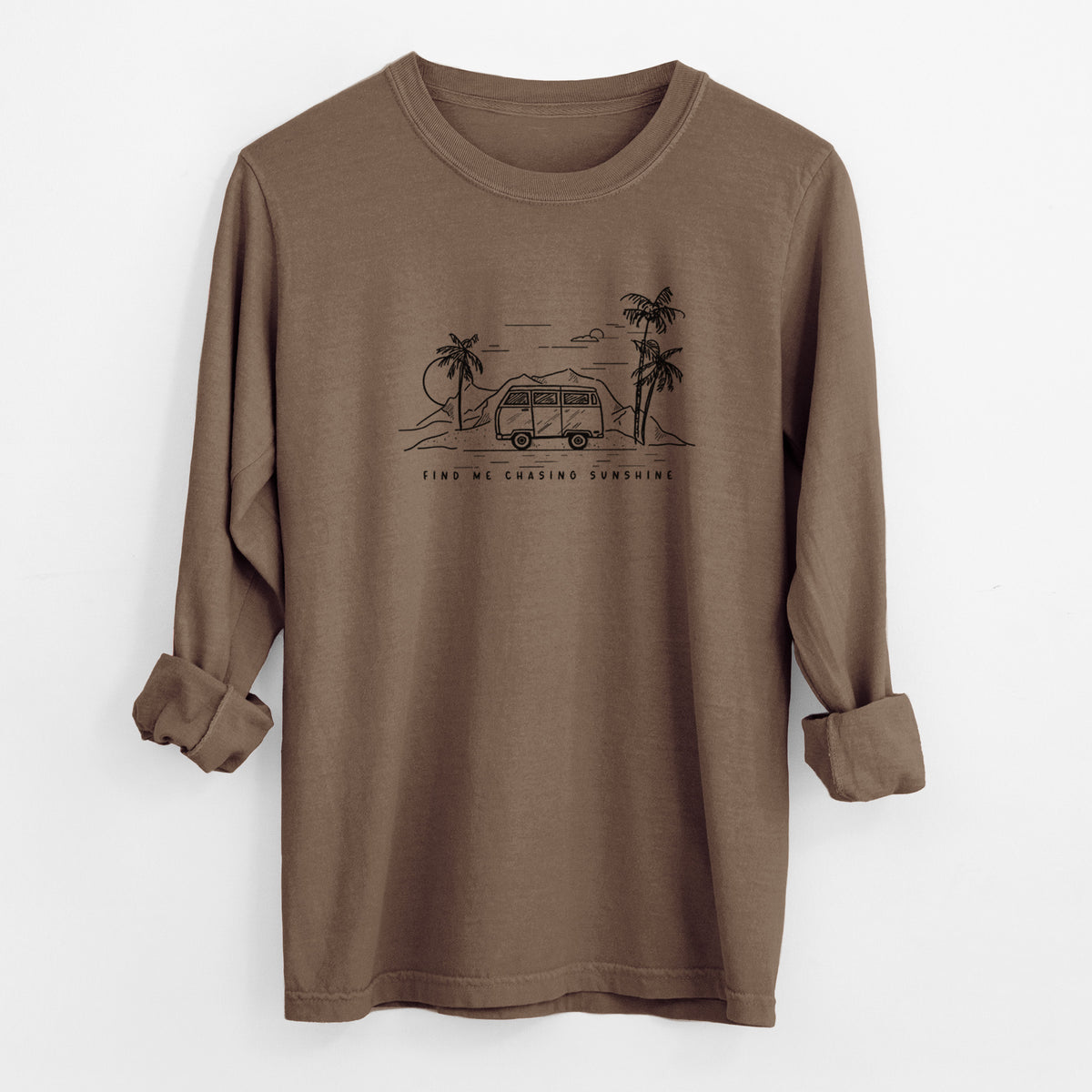 Espresso brown Comfort Colors long sleeve shirt laid flat with the cuffs rolled, printed with a black ink illustration of a camper van under palm trees and the sun, with the words Find Me Chasing Sunshine.
