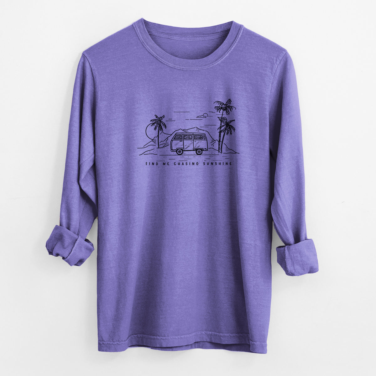 Violet purple Comfort Colors long sleeve shirt laid flat with the cuffs rolled, printed with a black ink illustration of a camper van under palm trees and the sun, with the words Find Me Chasing Sunshine.