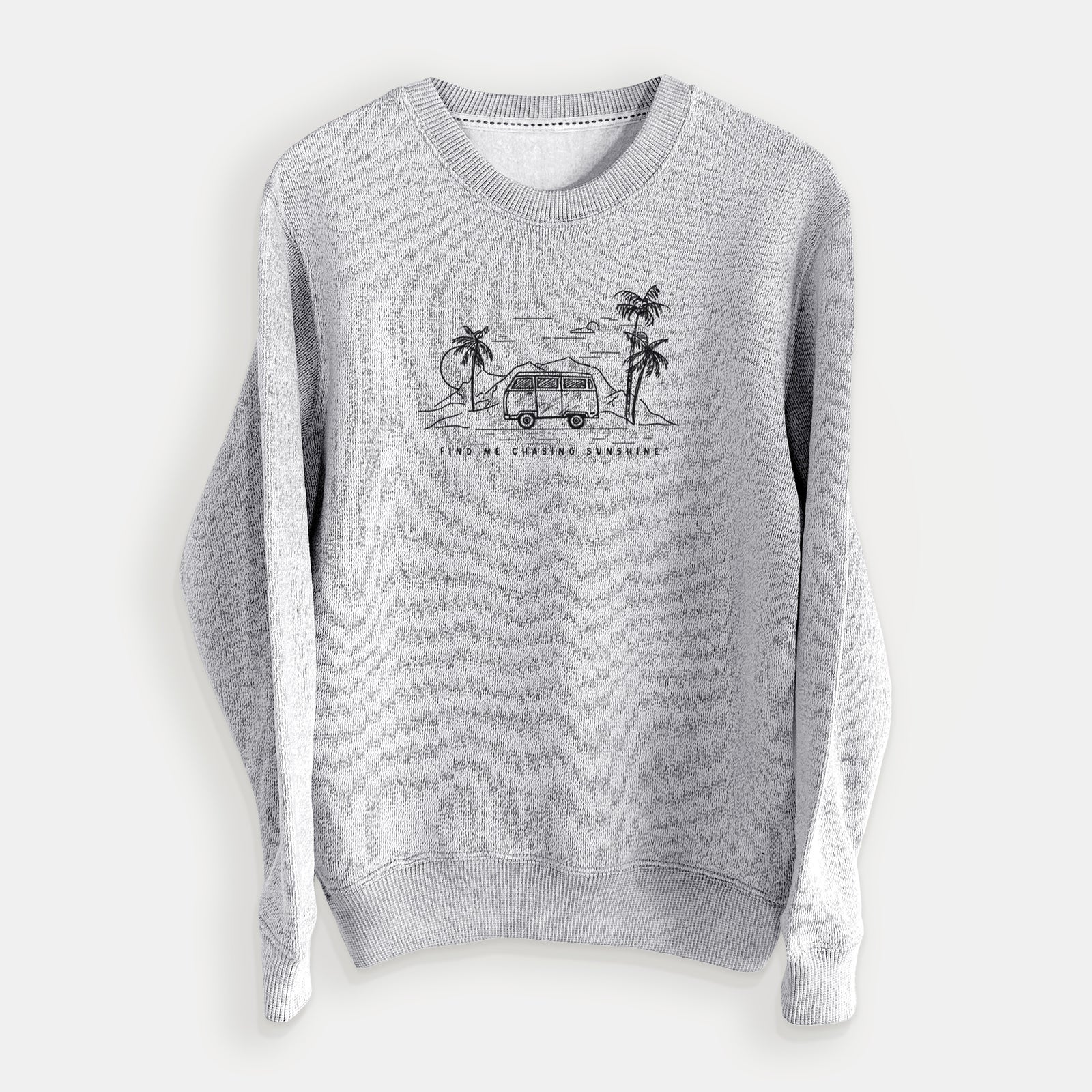 Salt and pepper knit sweatshirt laid flat, printed with a black ink illustration of a camper van under palm trees and the sun, with the words Find Me Chasing Sunshine.