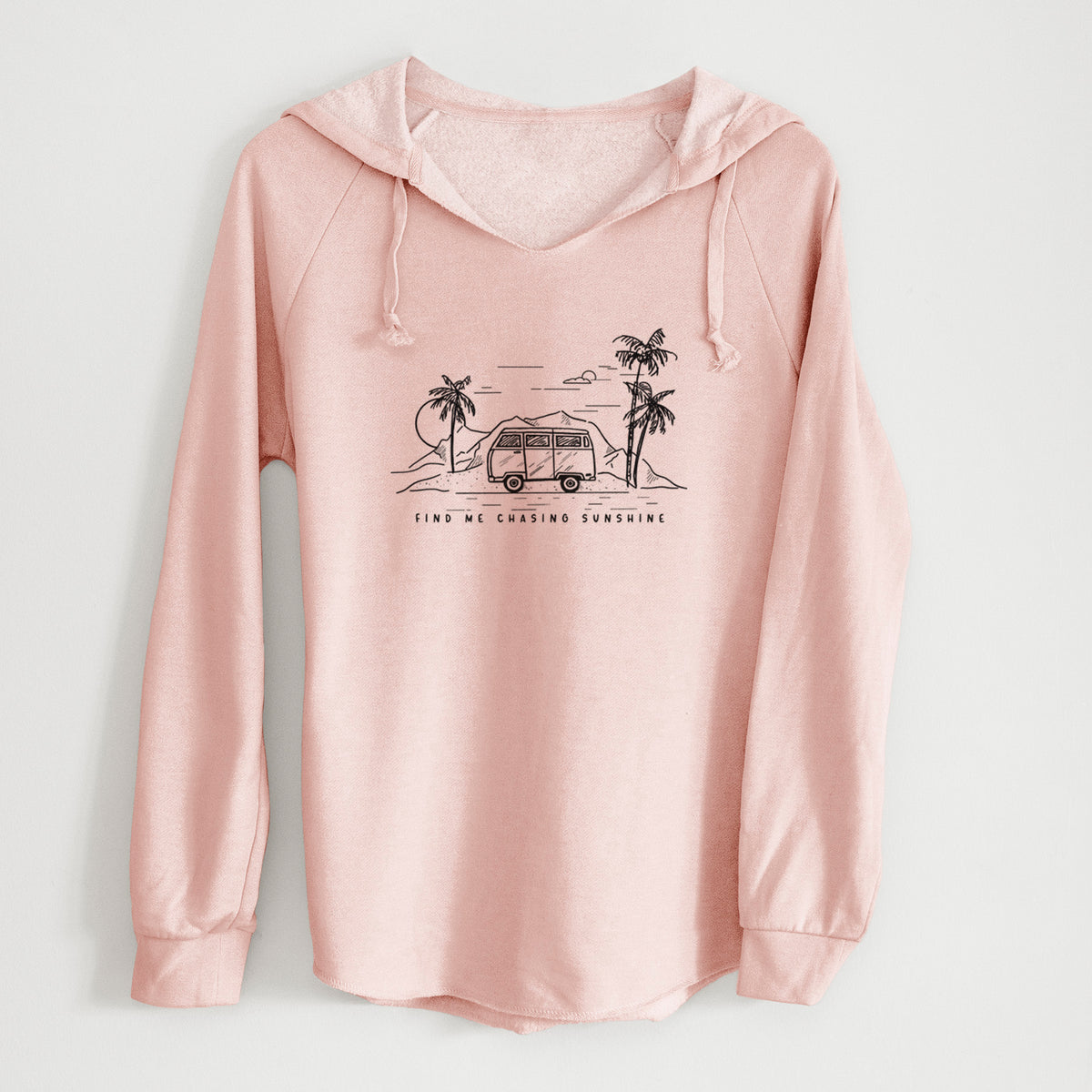 Blush pink women's Cali Wave hooded sweatshirt laid flat, printed with a black ink illustration of a camper van under palm trees and the sun, with the words Find Me Chasing Sunshine.