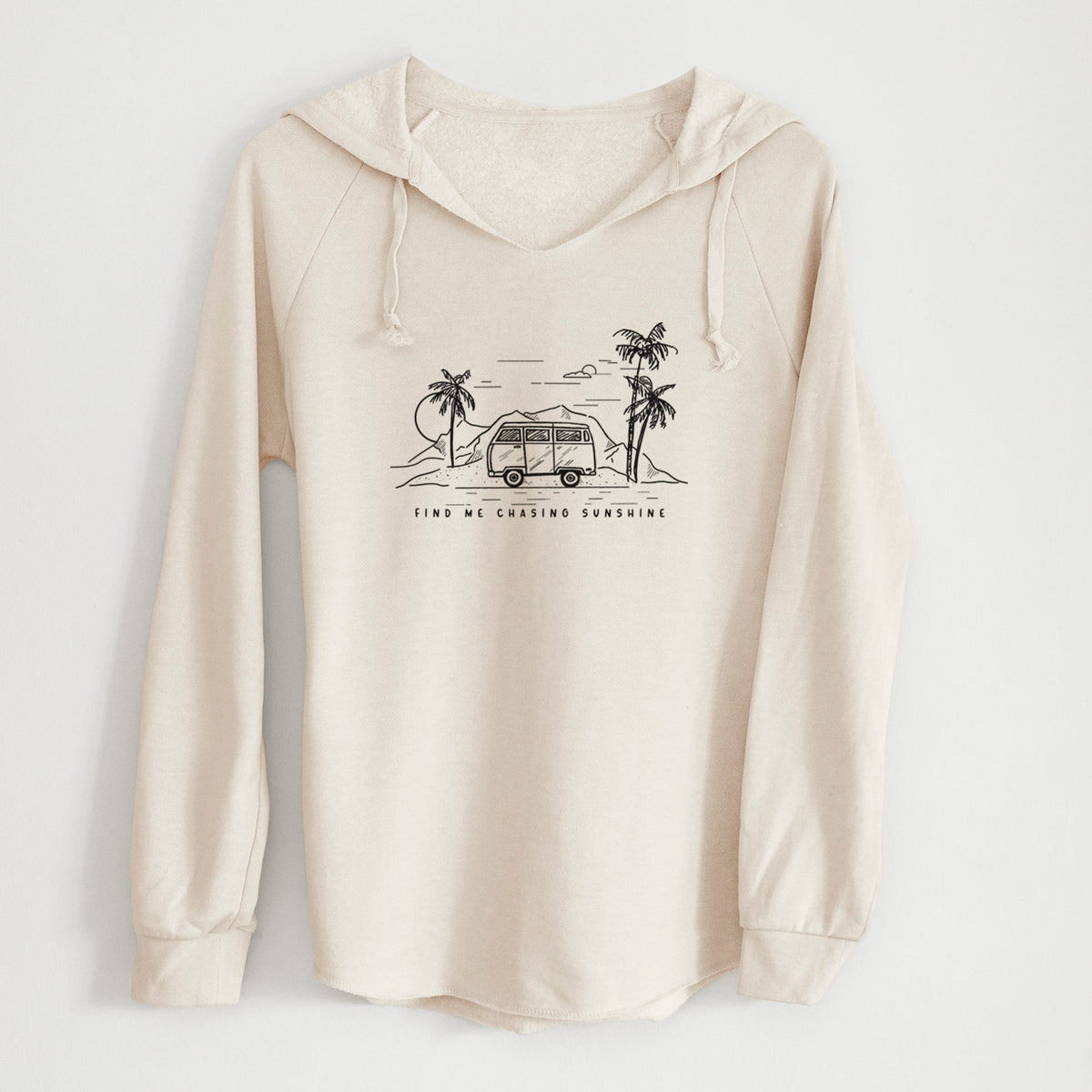 Bone cream women's Cali Wave hooded sweatshirt laid flat, printed with a black ink illustration of a camper van under palm trees and the sun, with the words Find Me Chasing Sunshine.