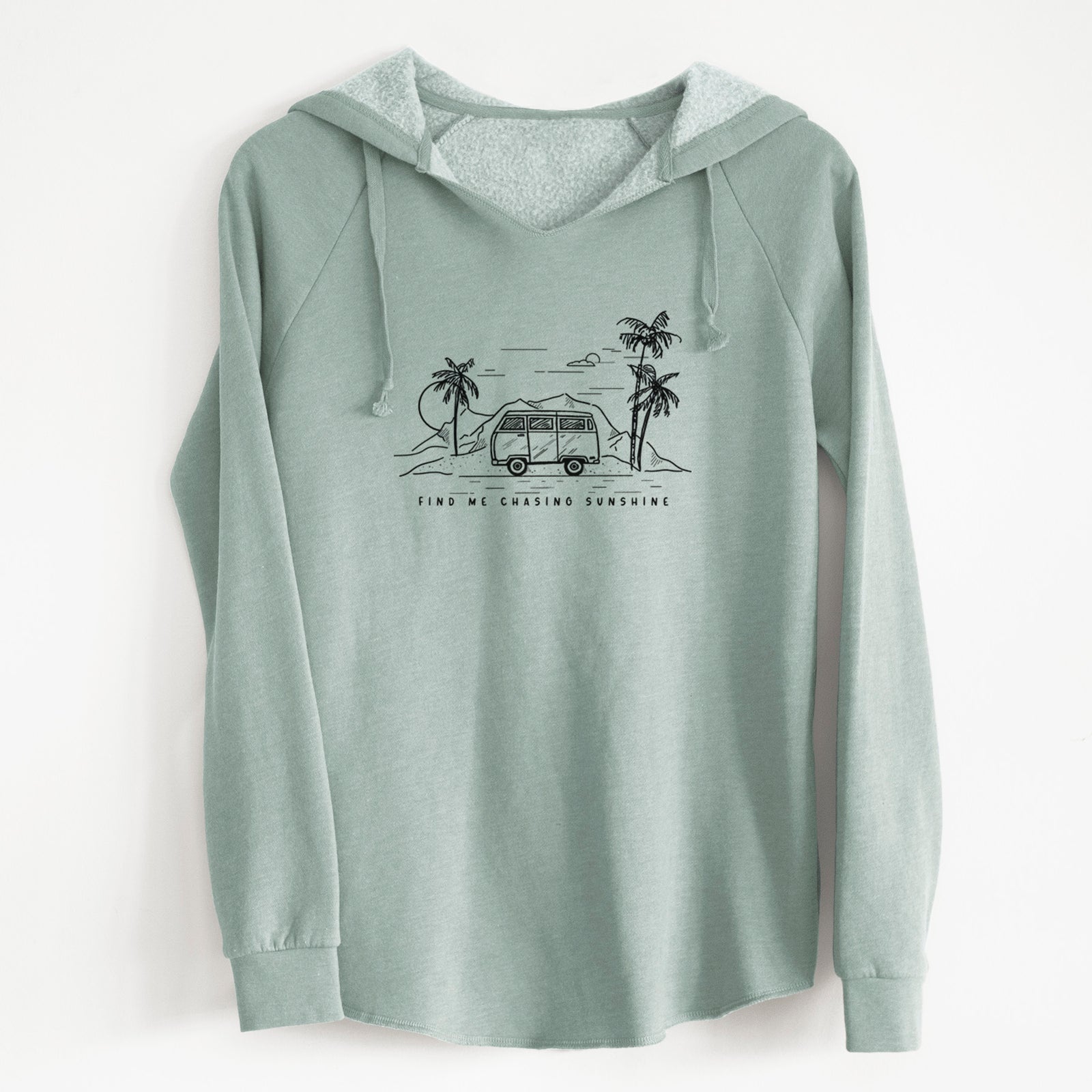 Sage green women's Cali Wave hooded sweatshirt laid flat, printed with a black ink illustration of a camper van under palm trees and the sun, with the words Find Me Chasing Sunshine.