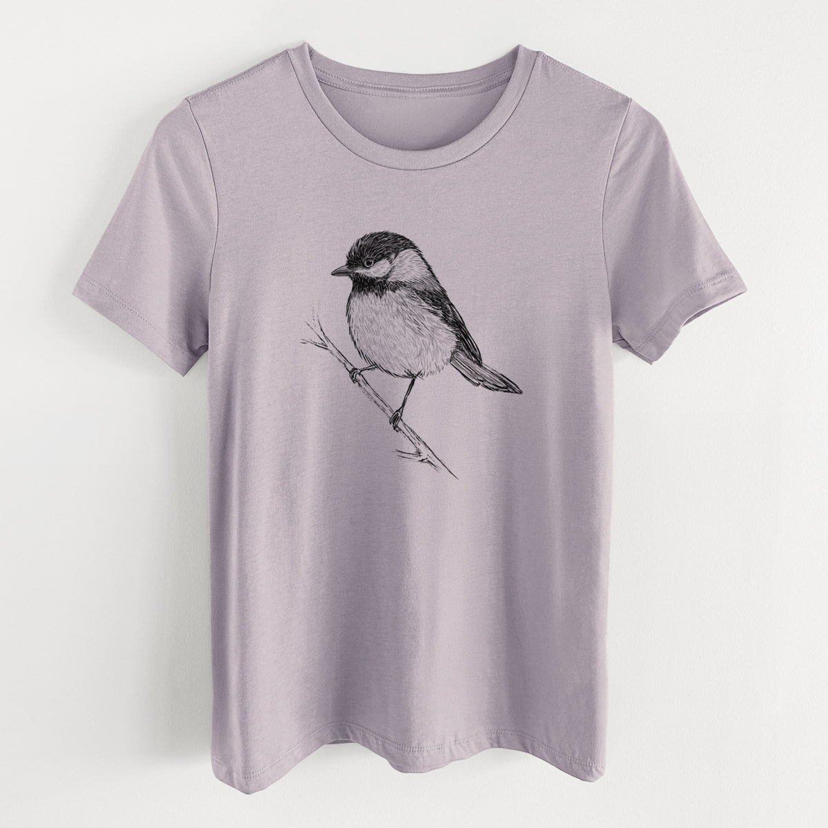 Light violet women's relaxed fit cotton t-shirt laid flat, printed with a detailed black ink sketch of a black-capped chickadee perched on a branch.
