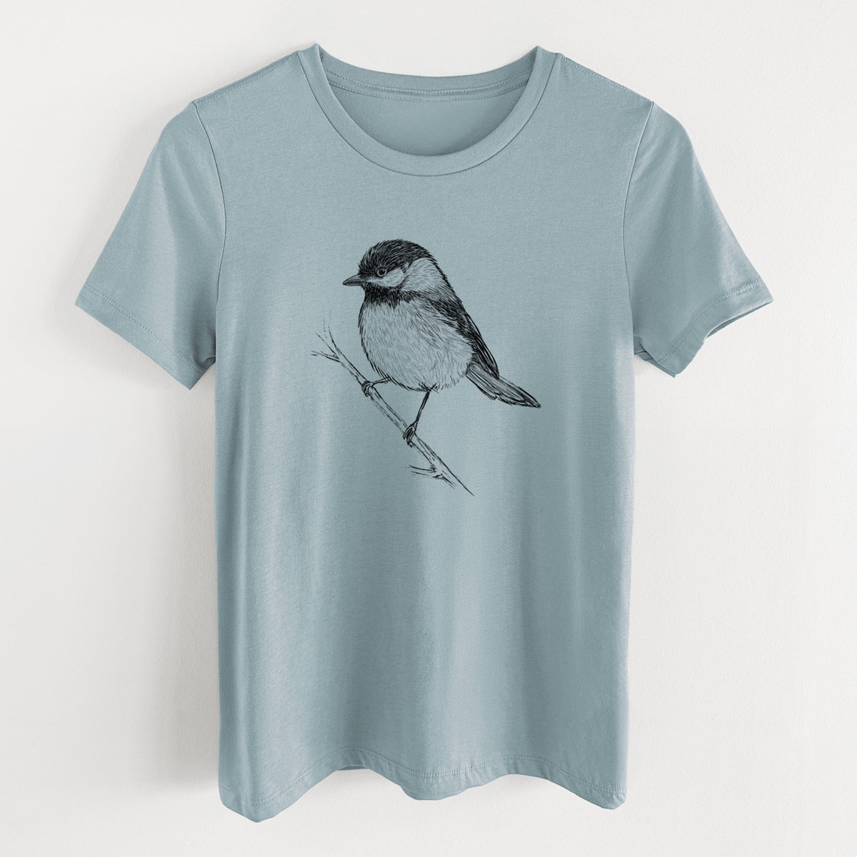 Vintage denim women's relaxed fit cotton t-shirt laid flat, printed with a detailed black ink sketch of a black-capped chickadee perched on a branch.