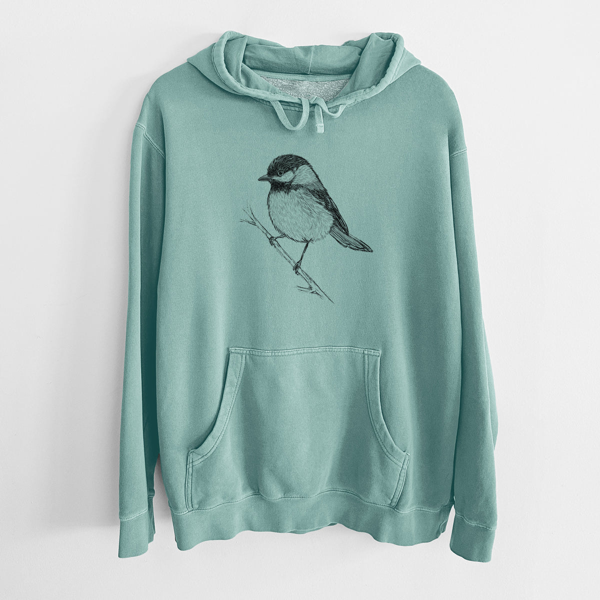 Mint green pigment dyed hoodie laid flat, printed with a detailed black ink sketch of a black-capped chickadee perched on a branch.
